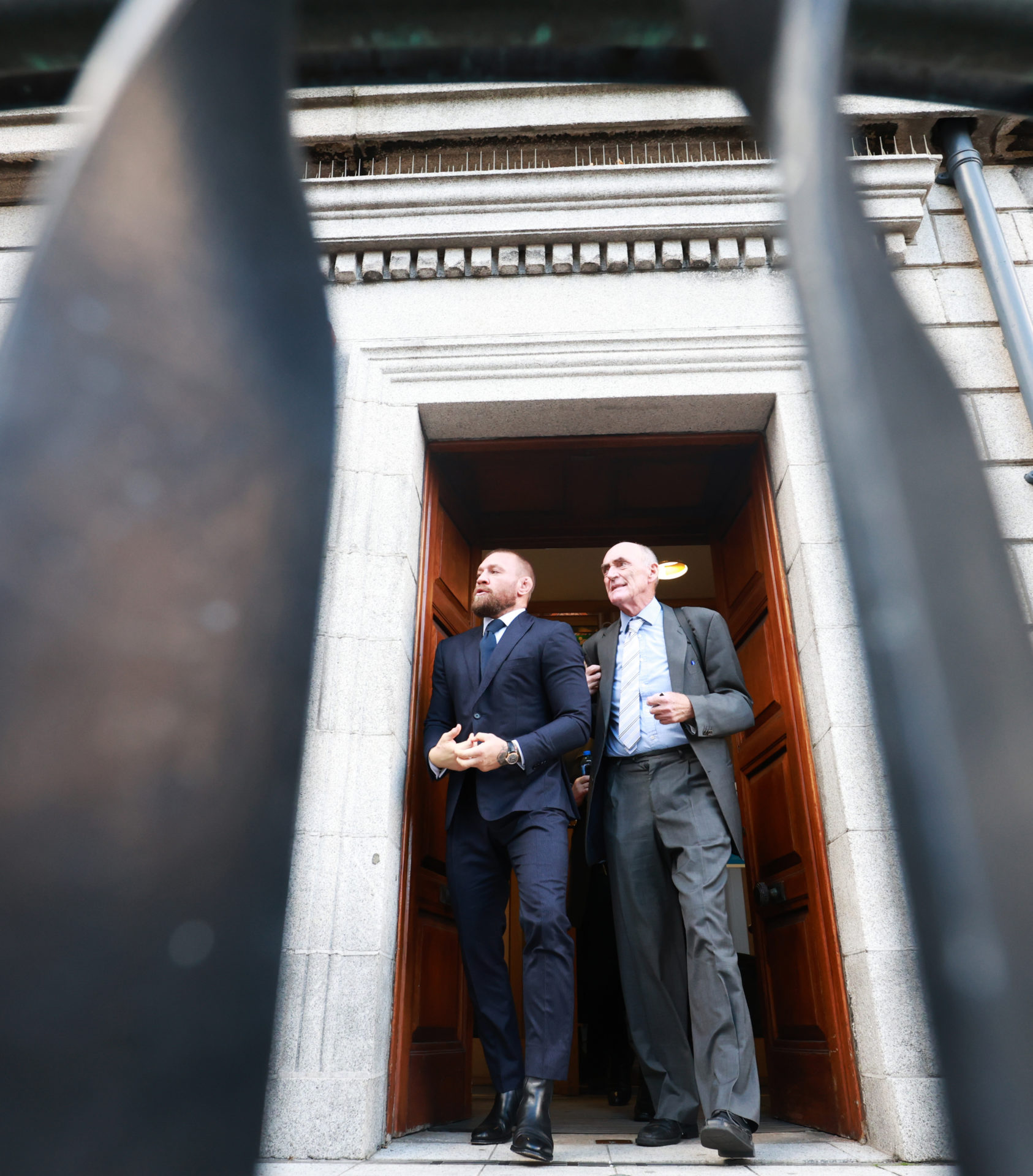 Conor McGregor and solicitor Michael Staines leave the High Court today