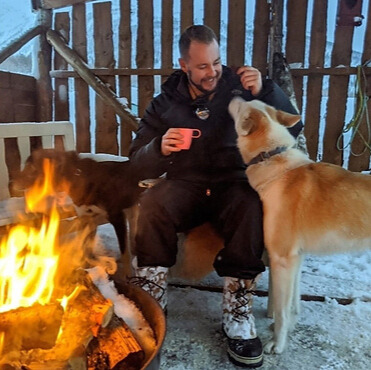 Craig Ballentine from Co. Tyrone photographed in front of a fire with a dog. 