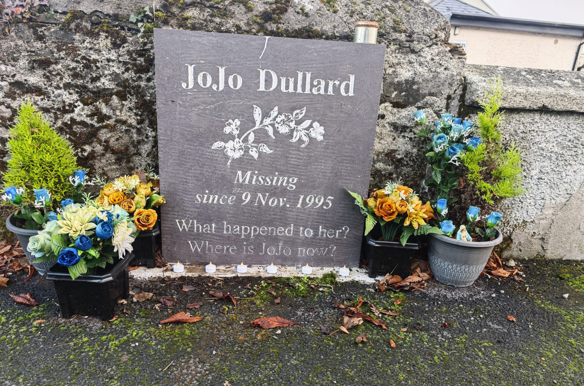 Jo Jo Dullard' memorial surrounded by flowers.