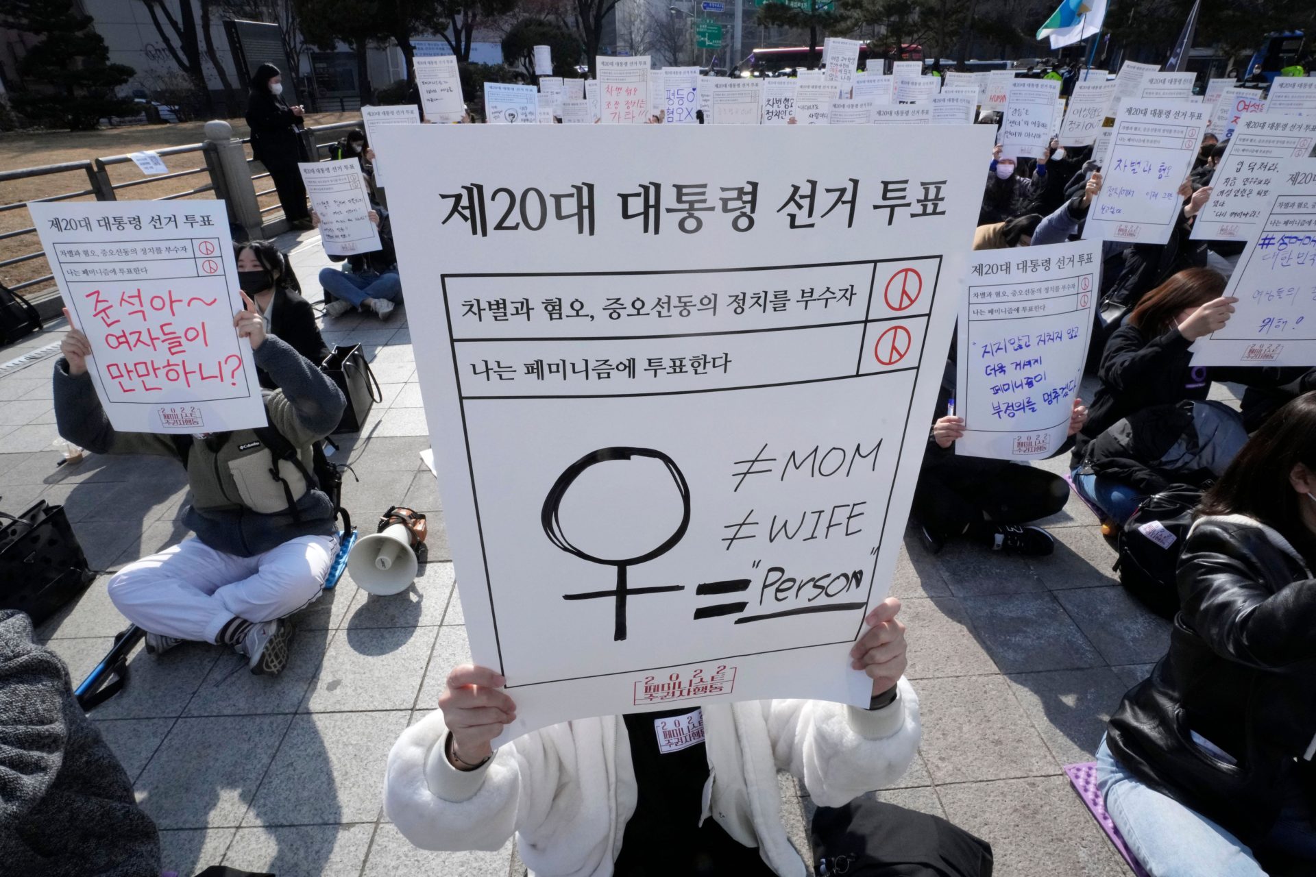 People stage a rally supporting feminism in Seoul, South Korea, Feb. 12, 2022. The signs at top read " The 20th Presidential Election Vote."