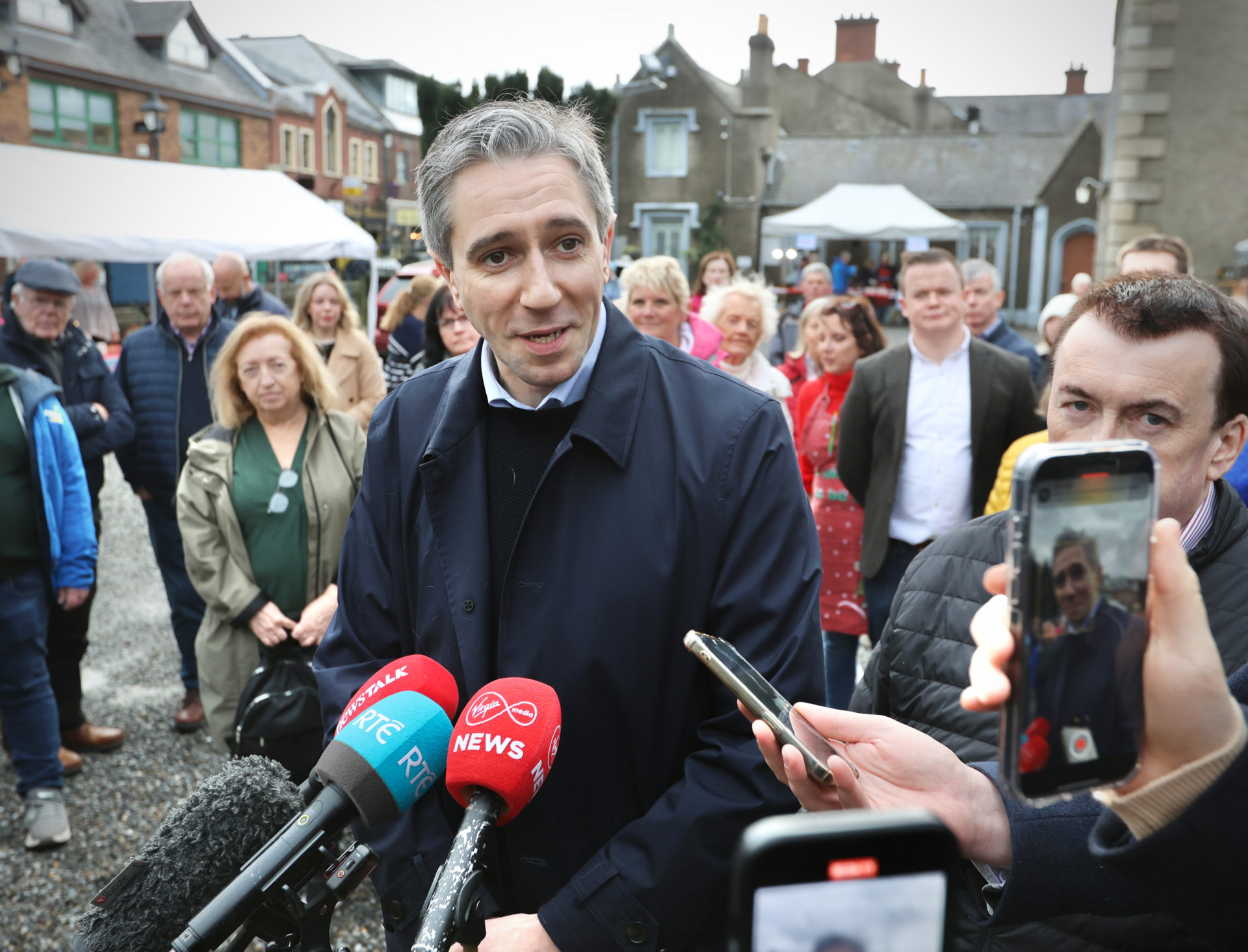 Simon Harris takes questions from the media while canvassing.