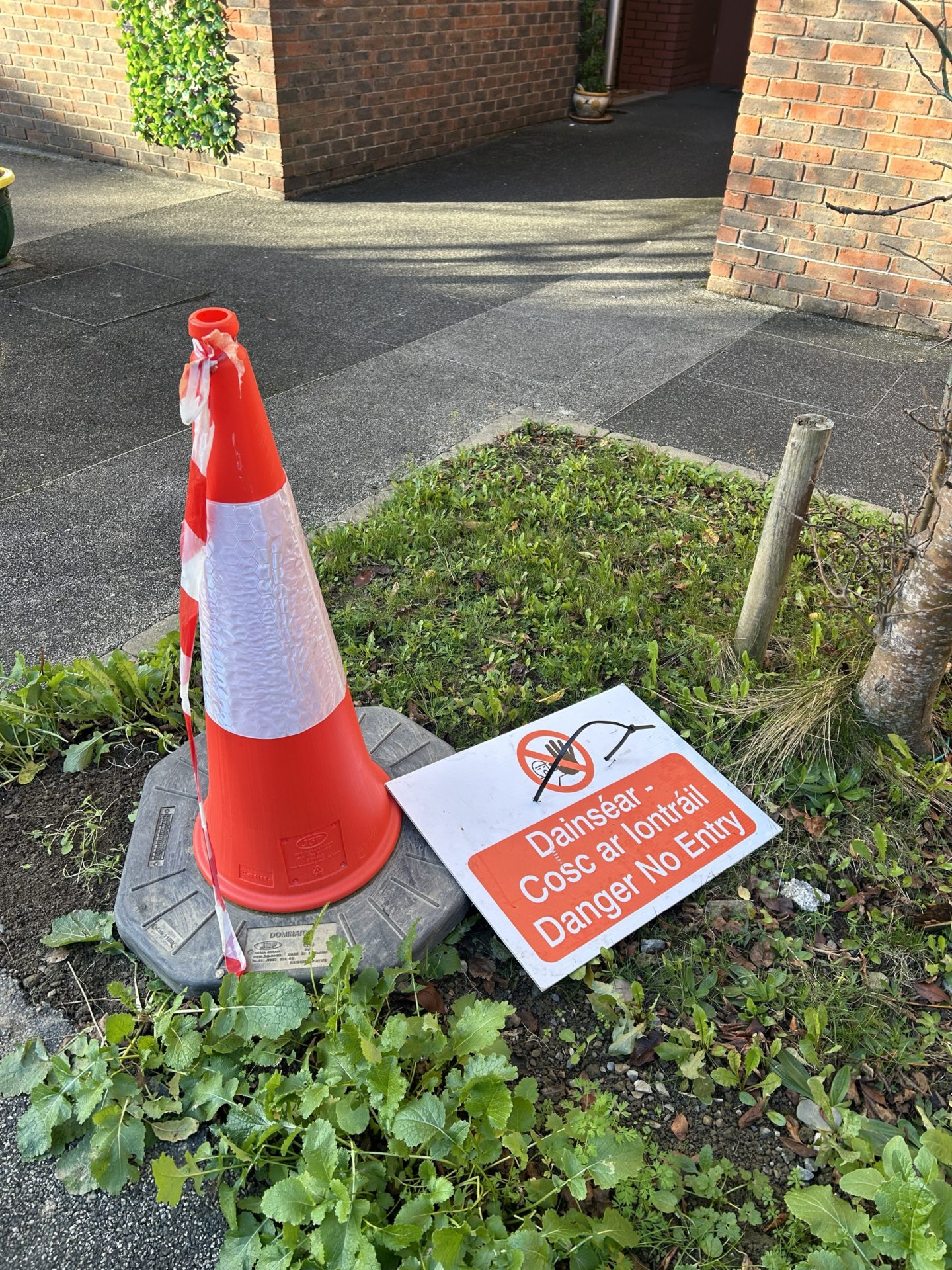 Traffic cone and red tape on the grounds of Claddagh Court. 