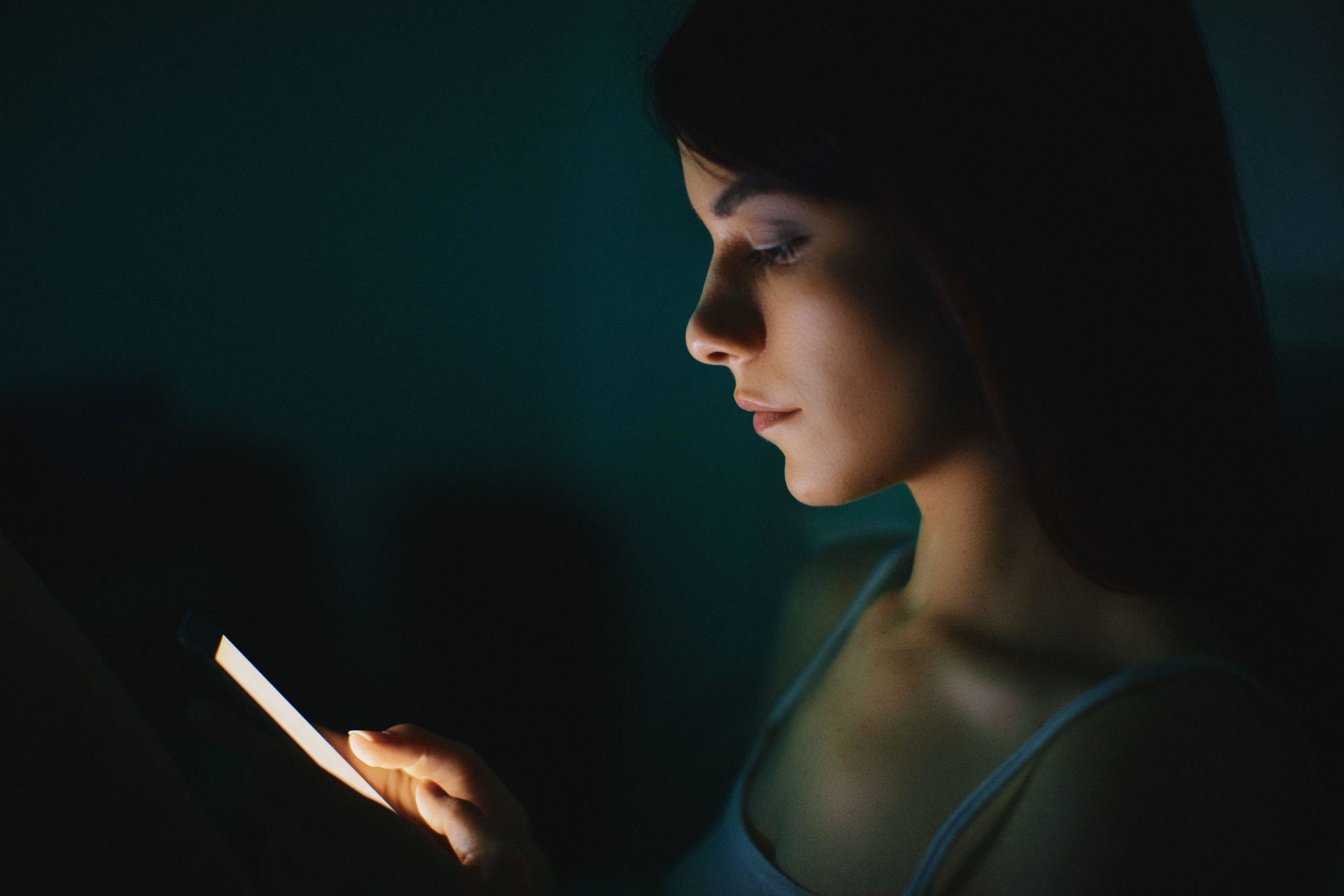 Image shows a woman looking at her phone