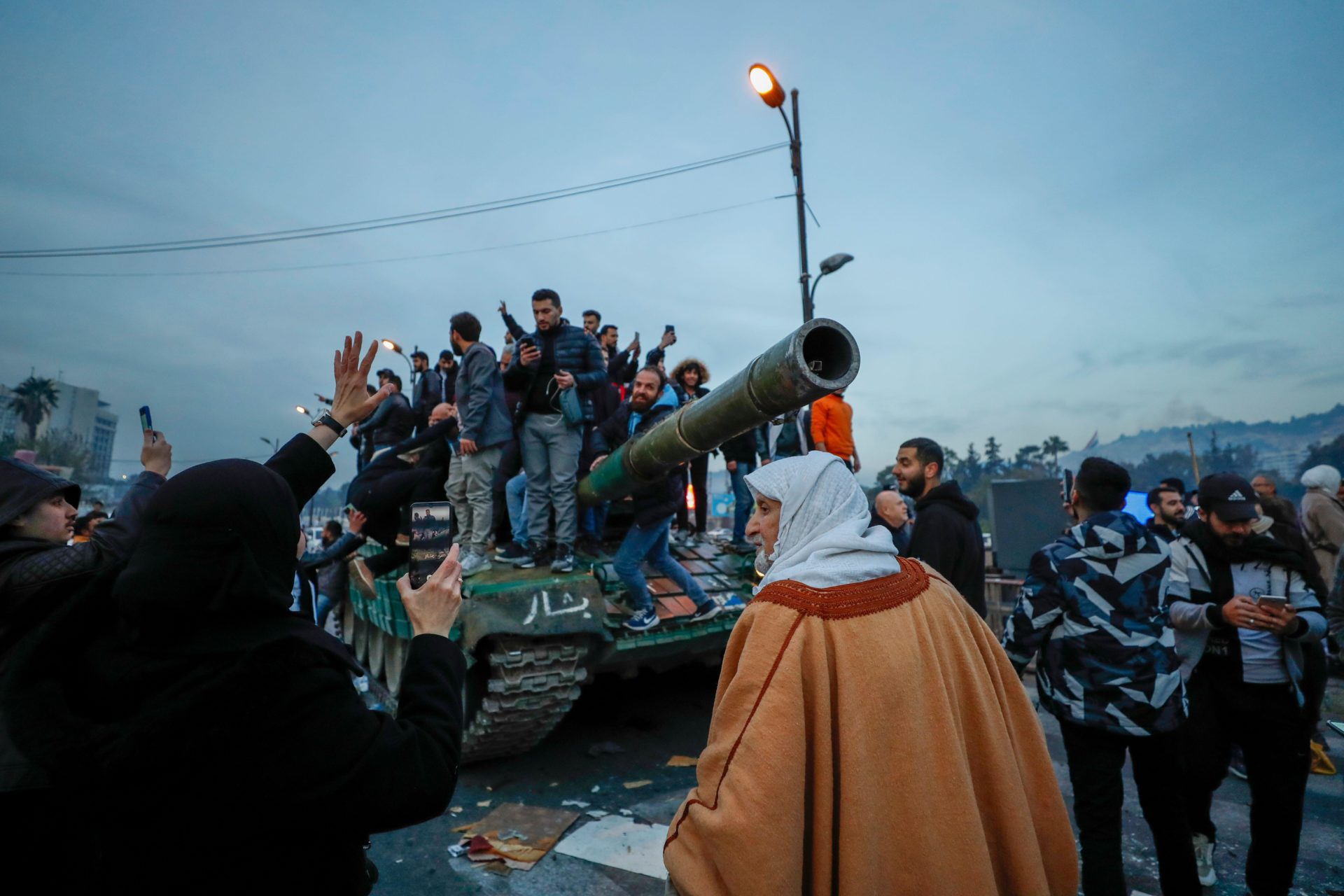 Syrians celebrate the arrival of opposition fighters in Damascus, Syria, Sunday Dec. 8.