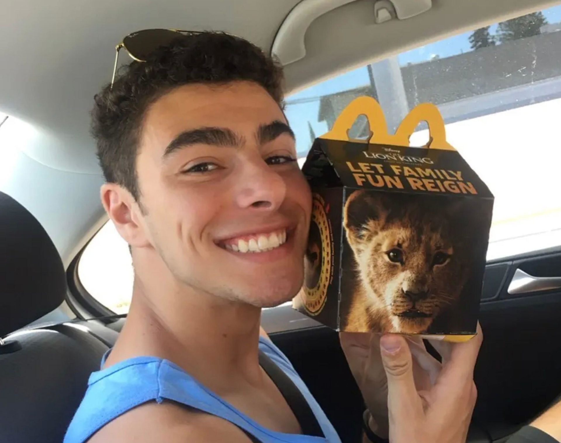 Luigi Mangione, seen on his Facebook personal page, holding a Disney 'LionKing Let Family Fun Reign' promo mailer in a car.