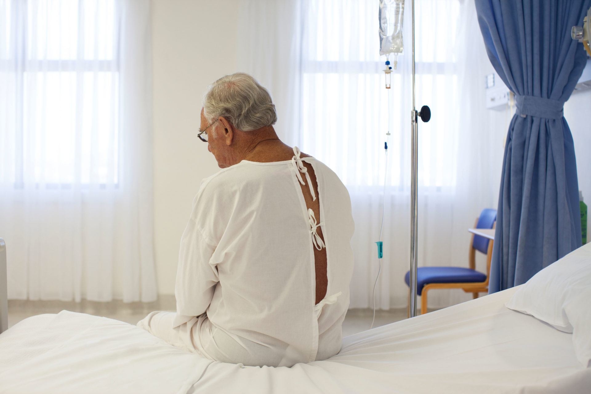 A patient sits on a hospital bed