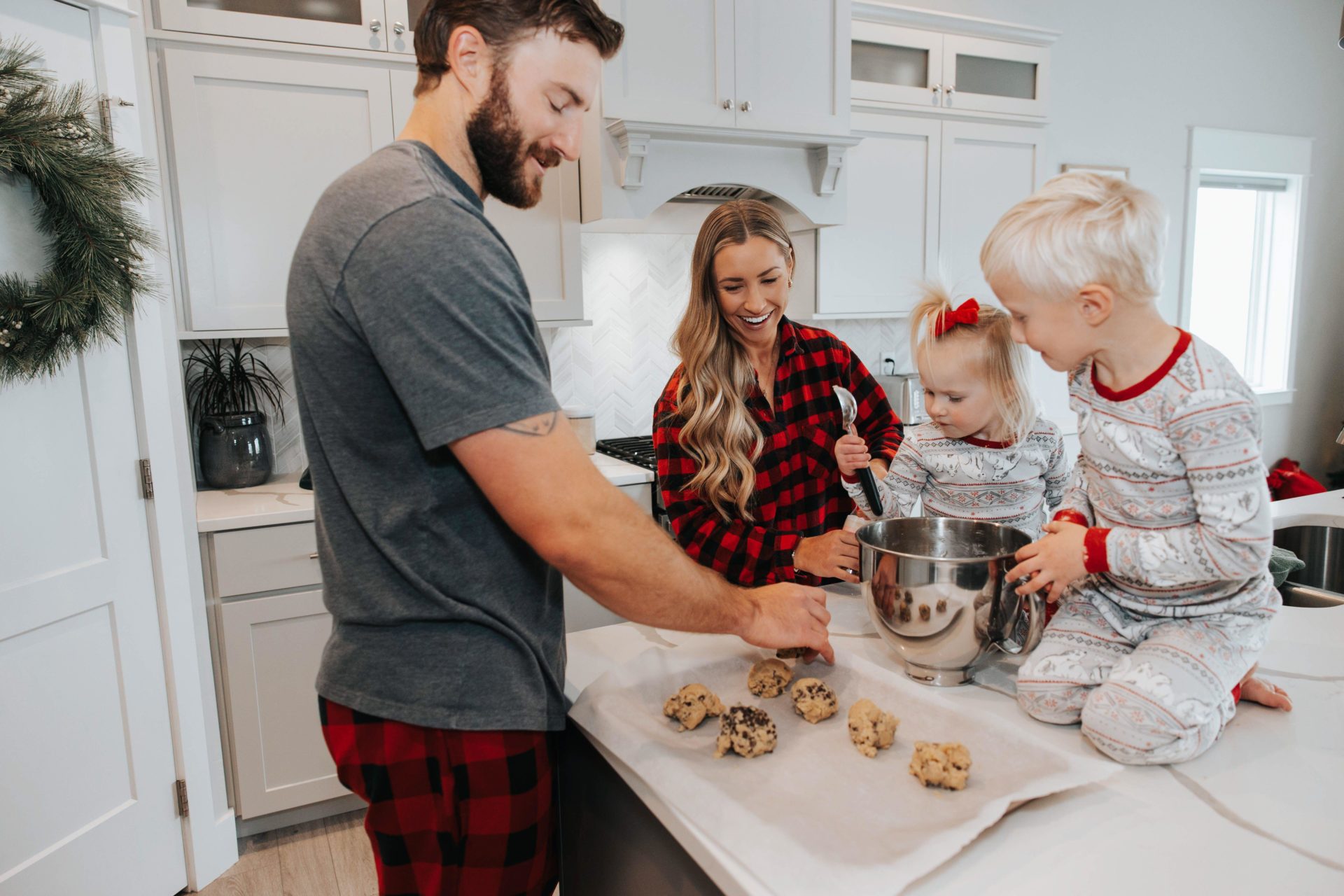 A family in Christmas pyjamas makes cookies together