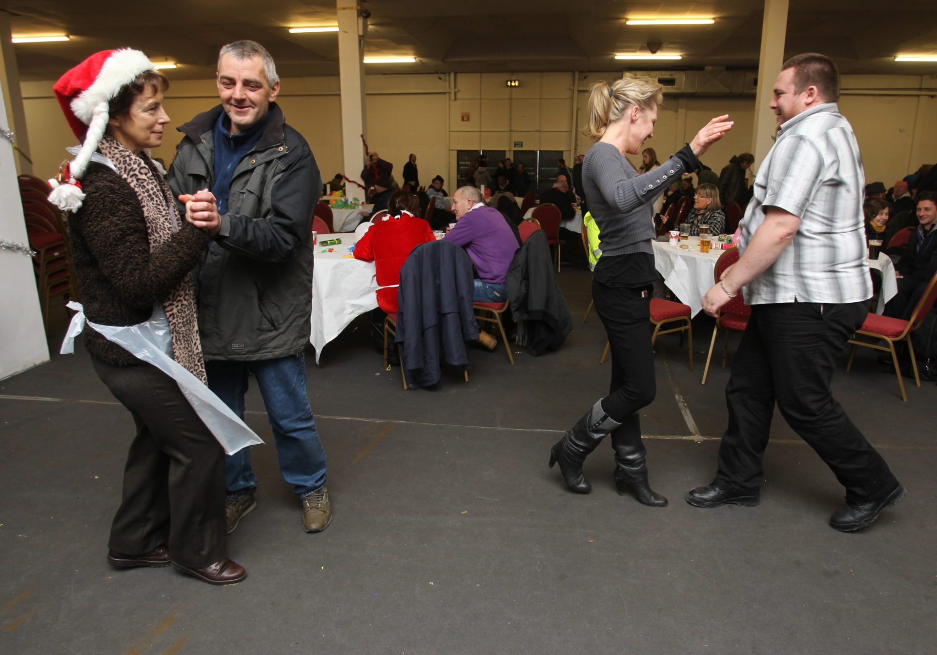 Charity Worker Linda Pickett dancing with Tommy Ryan and Susan Collins dances with Matt Browne at the Crosscare Hot Food Shelter Christmas diner in the RDS,on Christmas Day