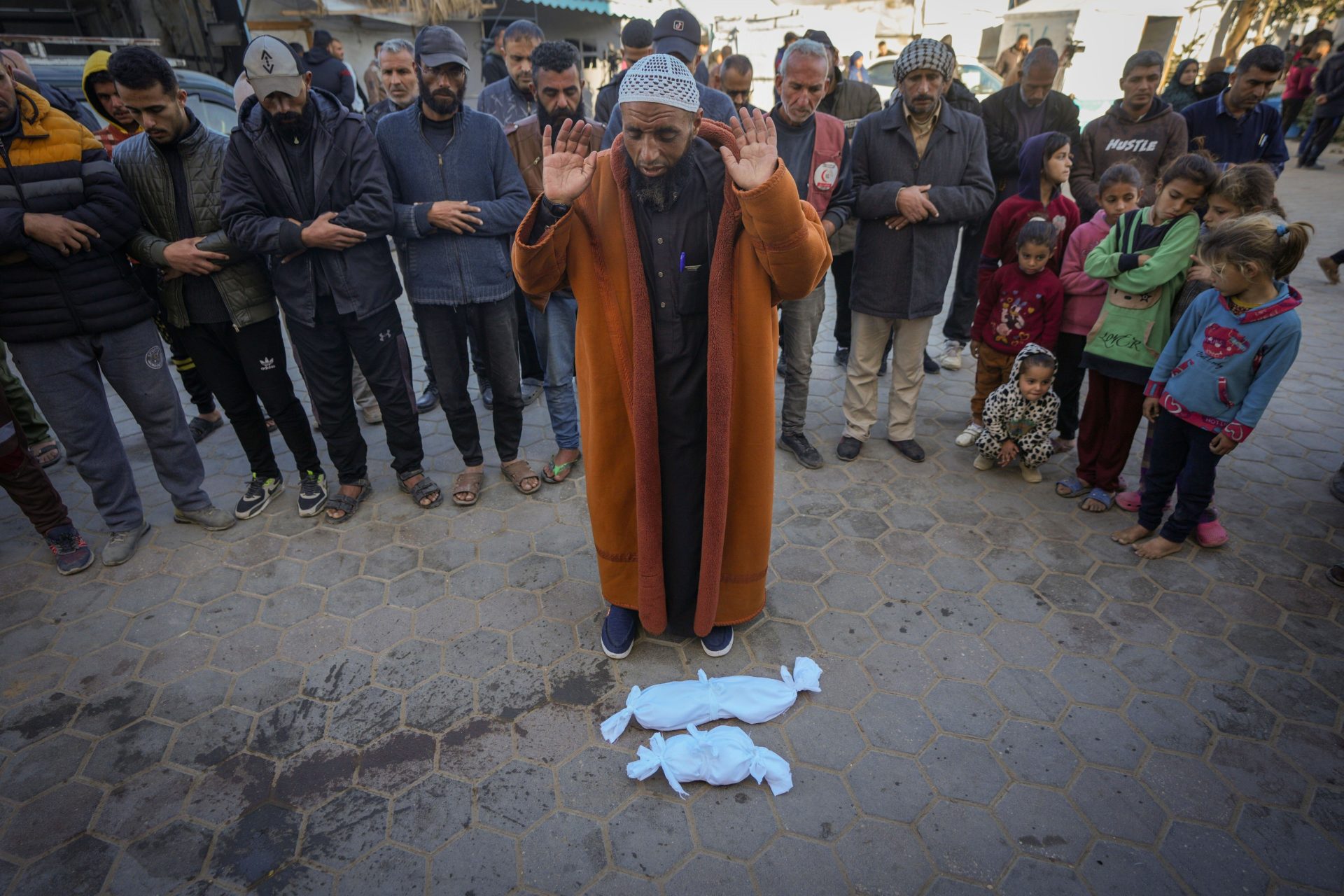 Imam Islam Abu Suaied prays over the bodies of two babies before their burial at the Al-Aqsa Martyrs Hospital in Deir al-Balah, central Gaza Strip.