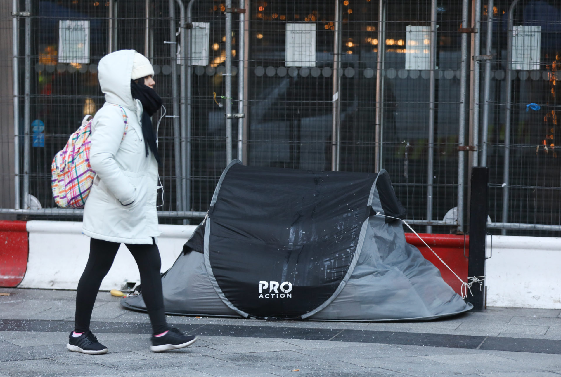 A pedestrian walking past a rough sleeper in a tent in Dublin City Centre.