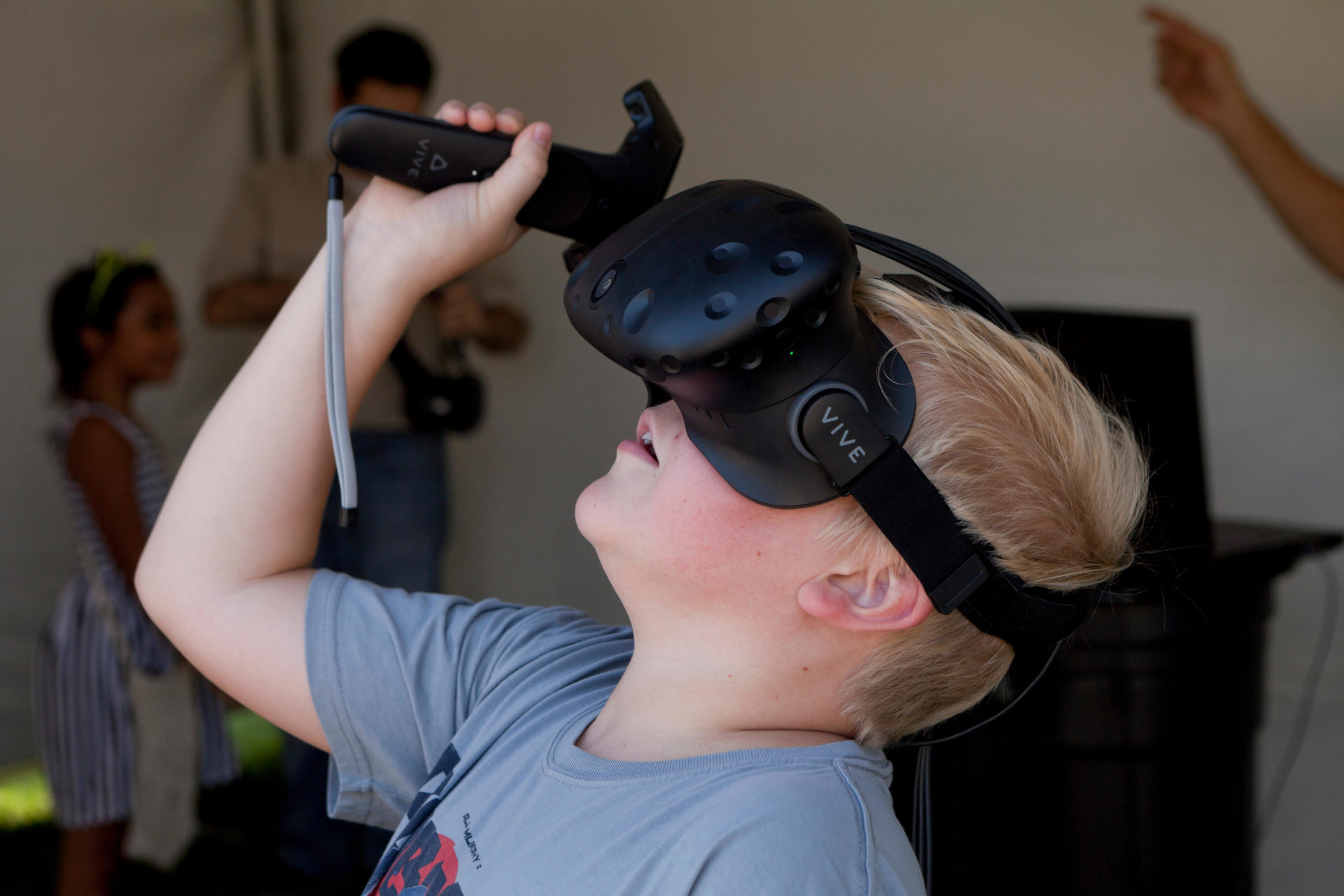 Child wearing VR headset (VR goggles) using bluetooth controlle.