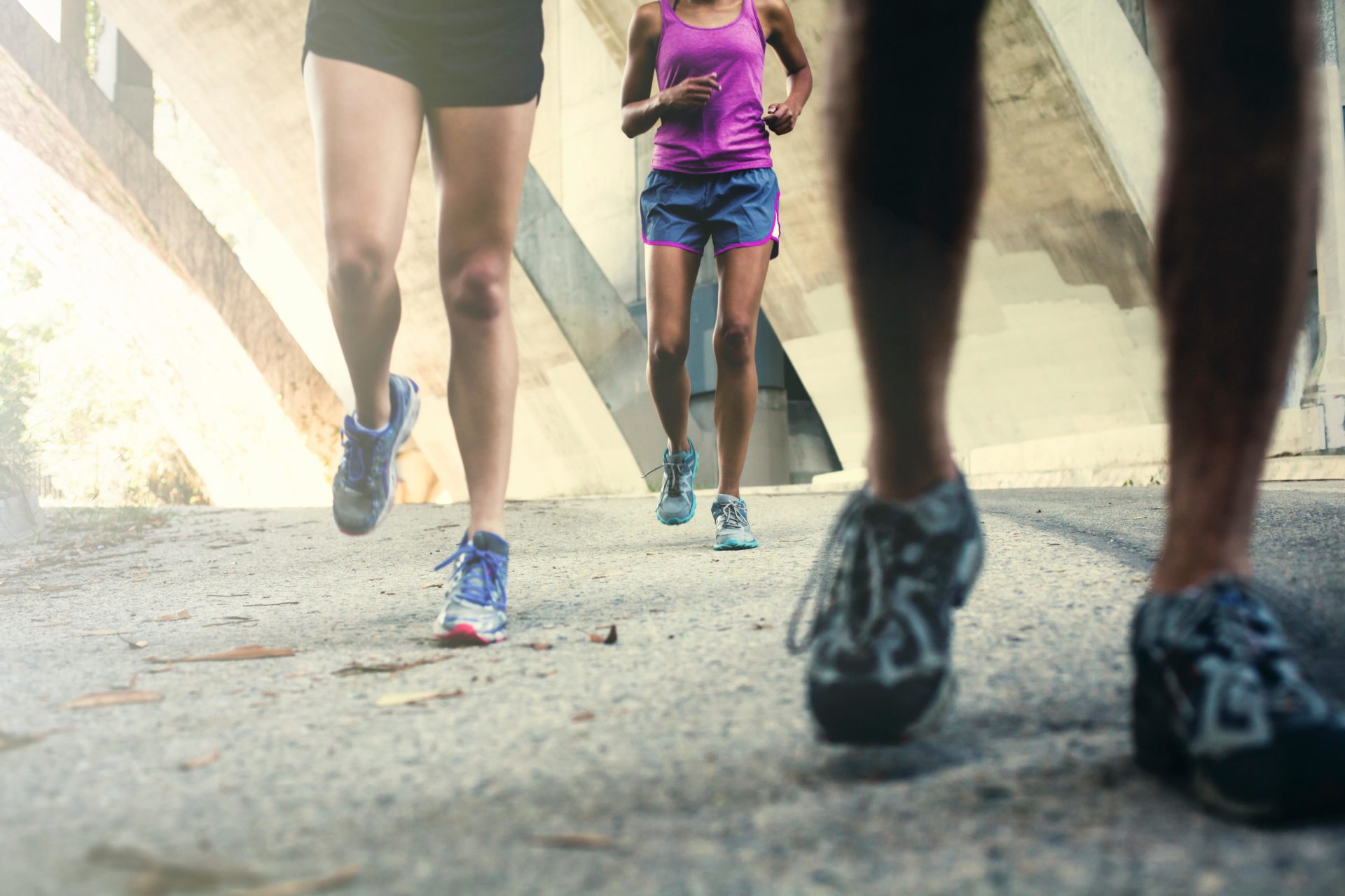 Image shows the feet of three joggers