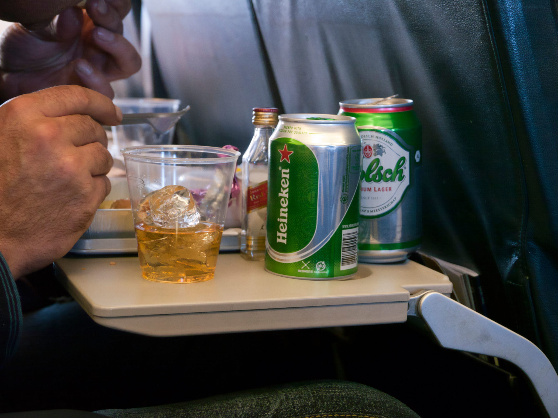 Alcohol being consumed by someone on a plane. 