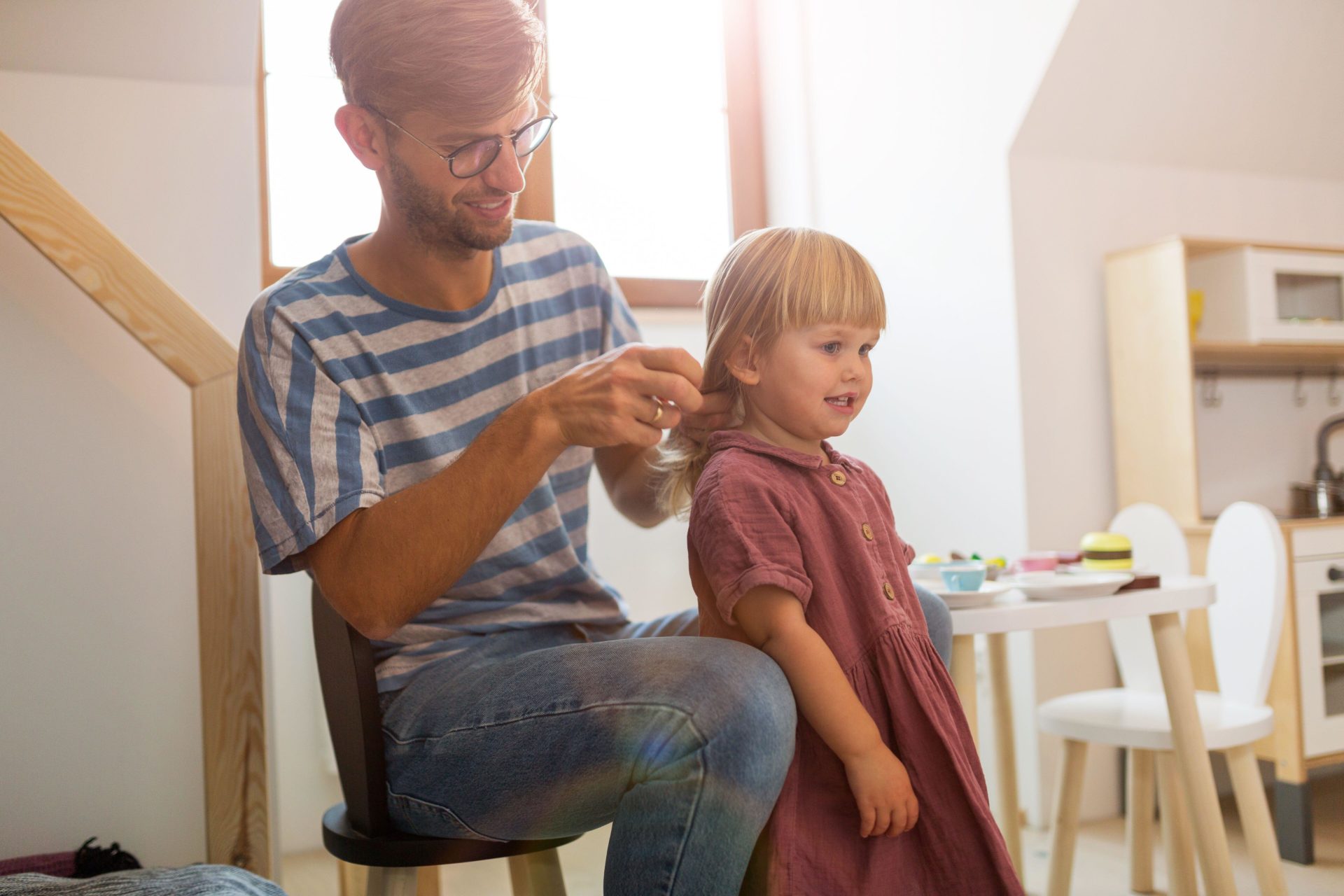 A father does his daughter's hair