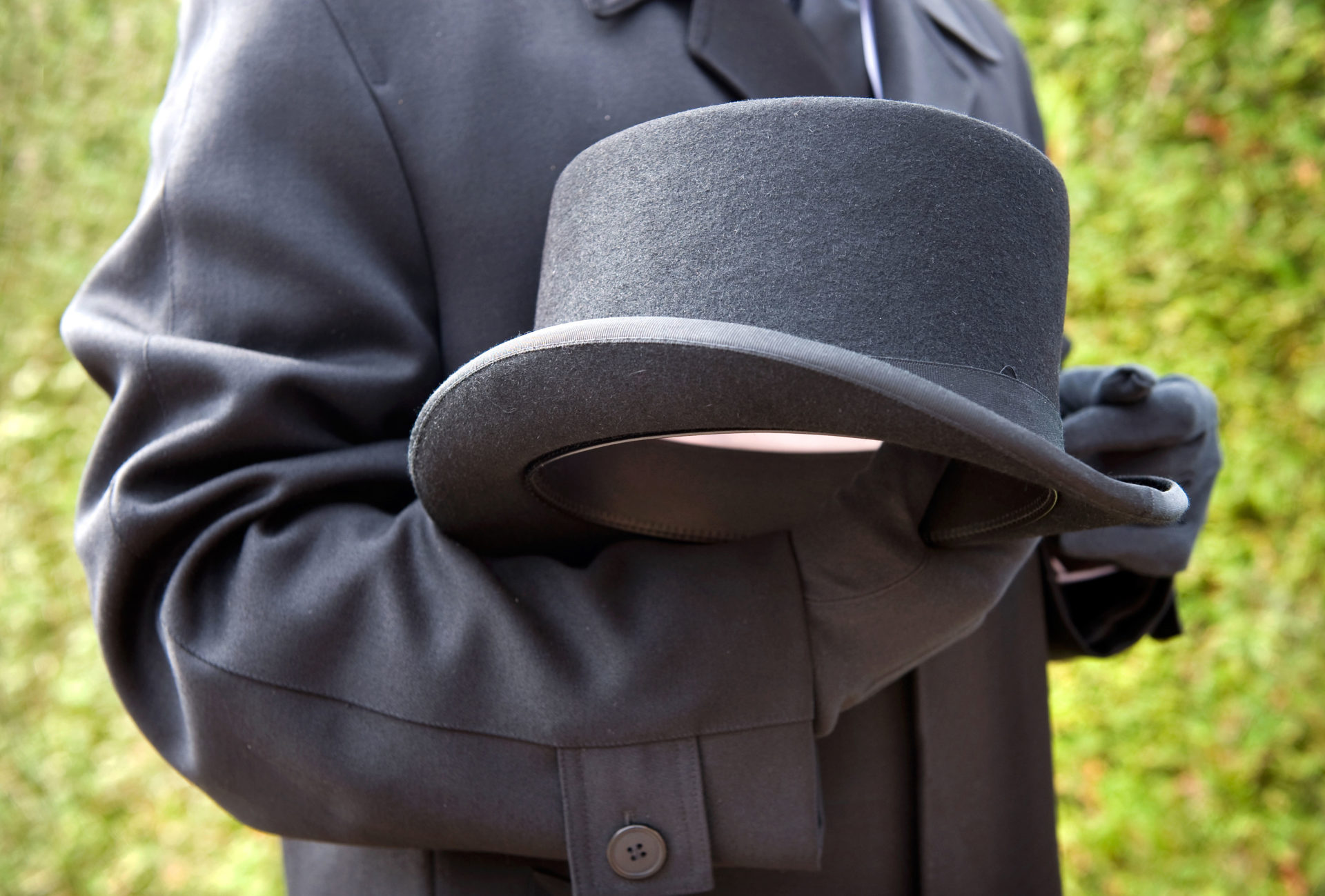 A funeral leader holds a a hat