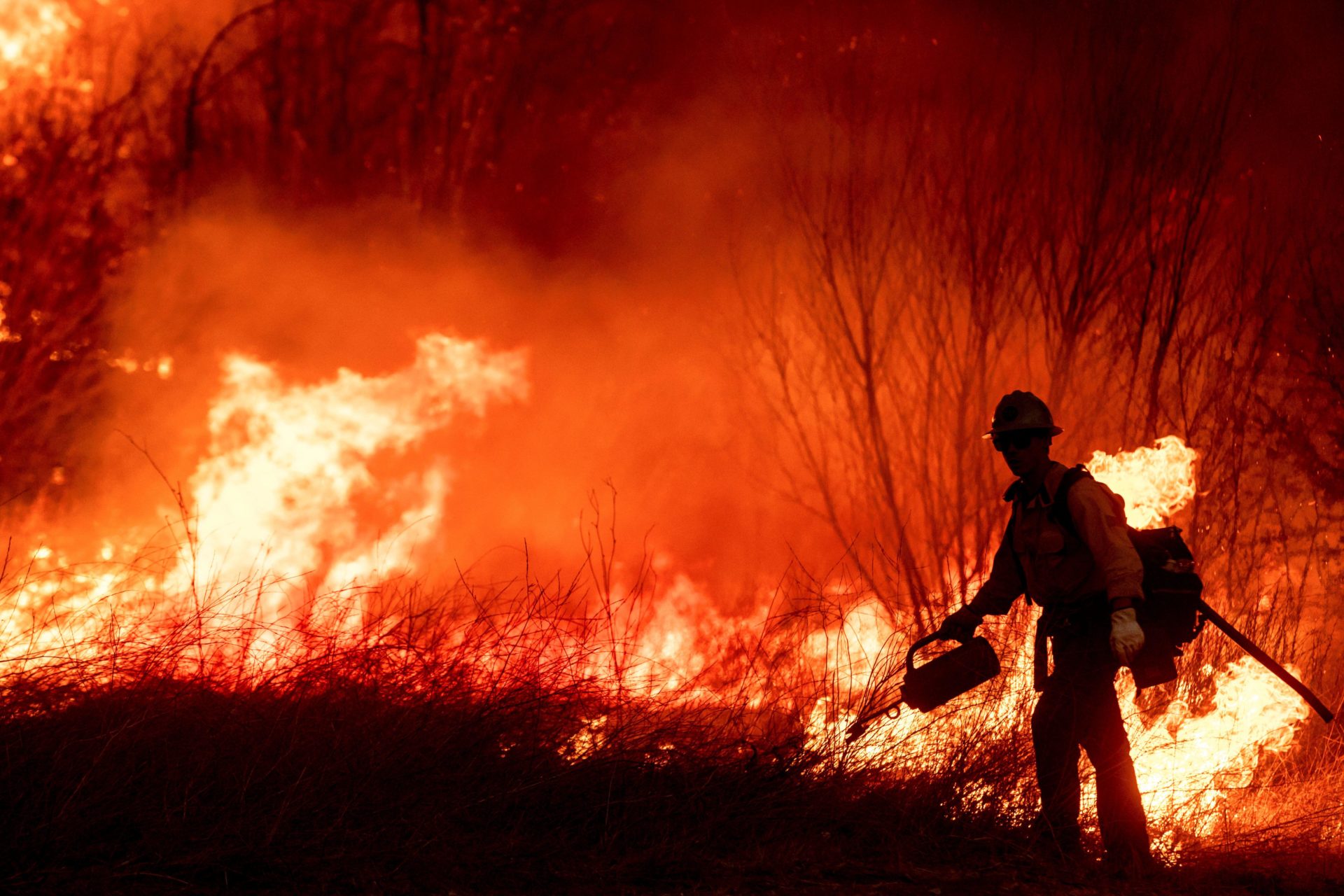 Firefighters work to extinguish a blaze caused by wildfires in California