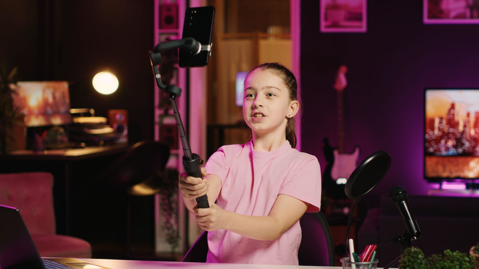 Young girl using smartphone attached to selfie stick to film content for her online accounts. fans, talking about gen Z topics. Image: Alamy