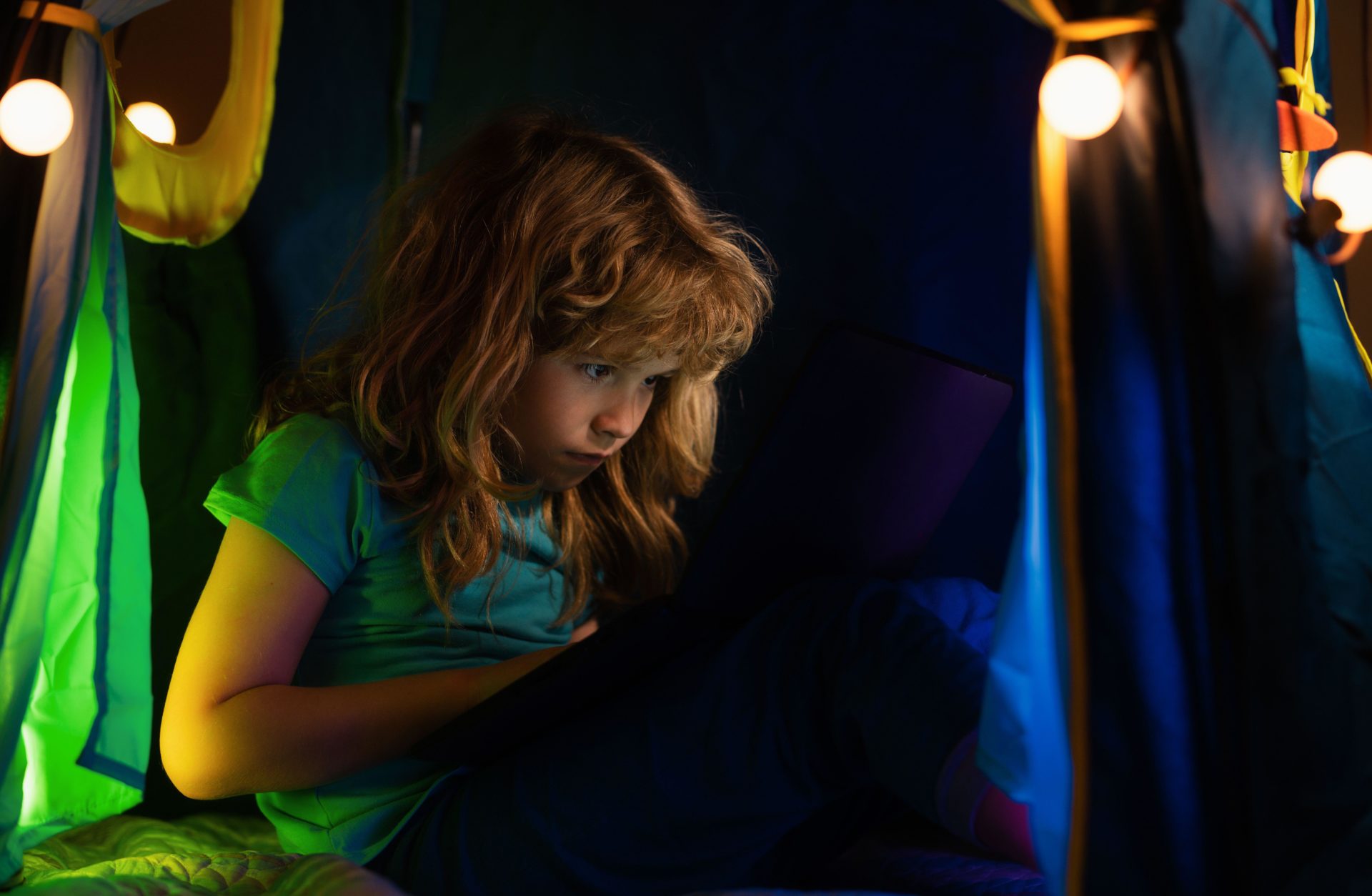 A child sits in front of a laptop screen. Image: Alamy