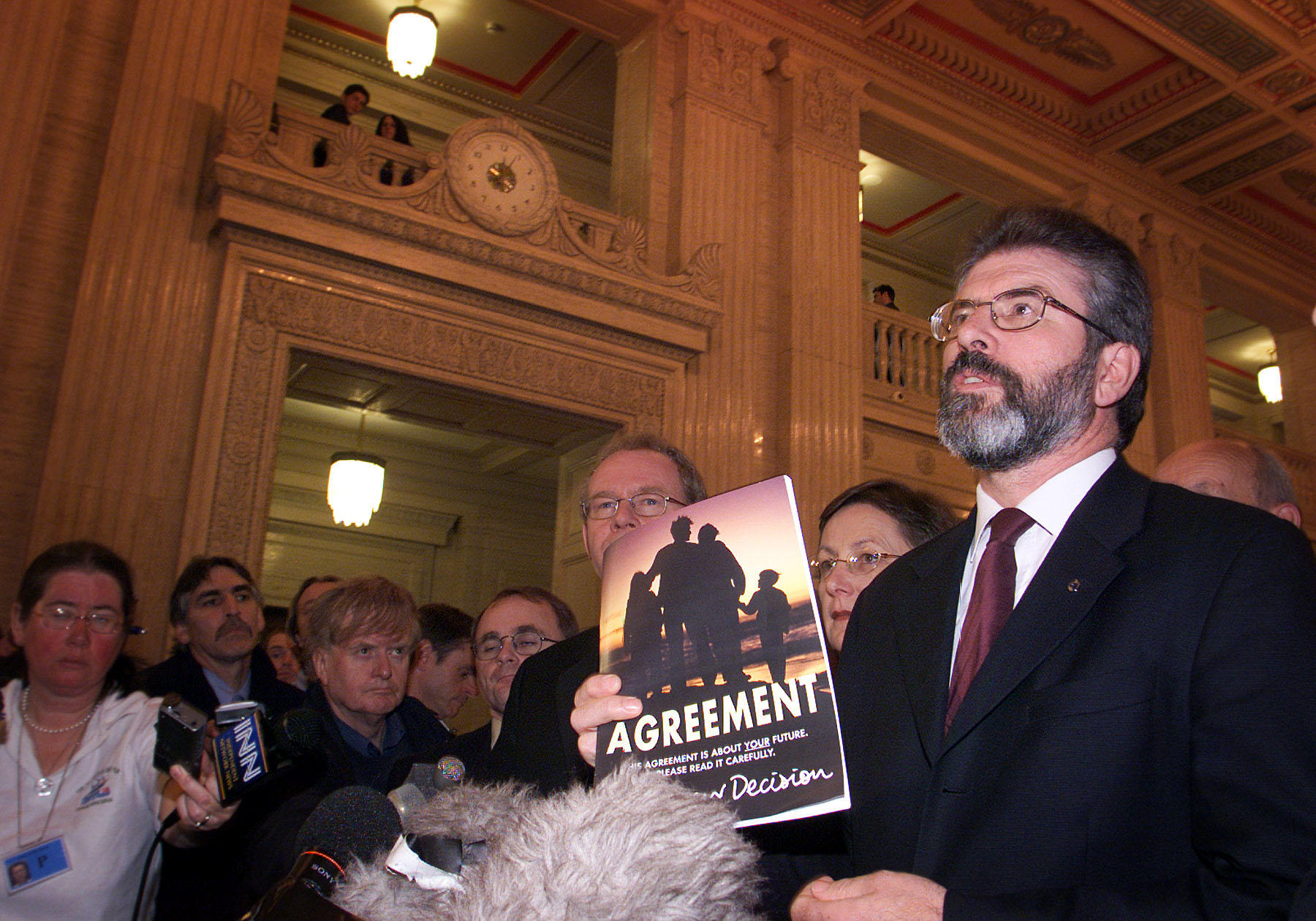 Sinn Fein President Gerry Adams holds a copy of the Good Friday Agreement, as he speaks to the media in Stormont after Northern Ireland Secretary of State John Reid announced the suspension of the power sharing Executive.