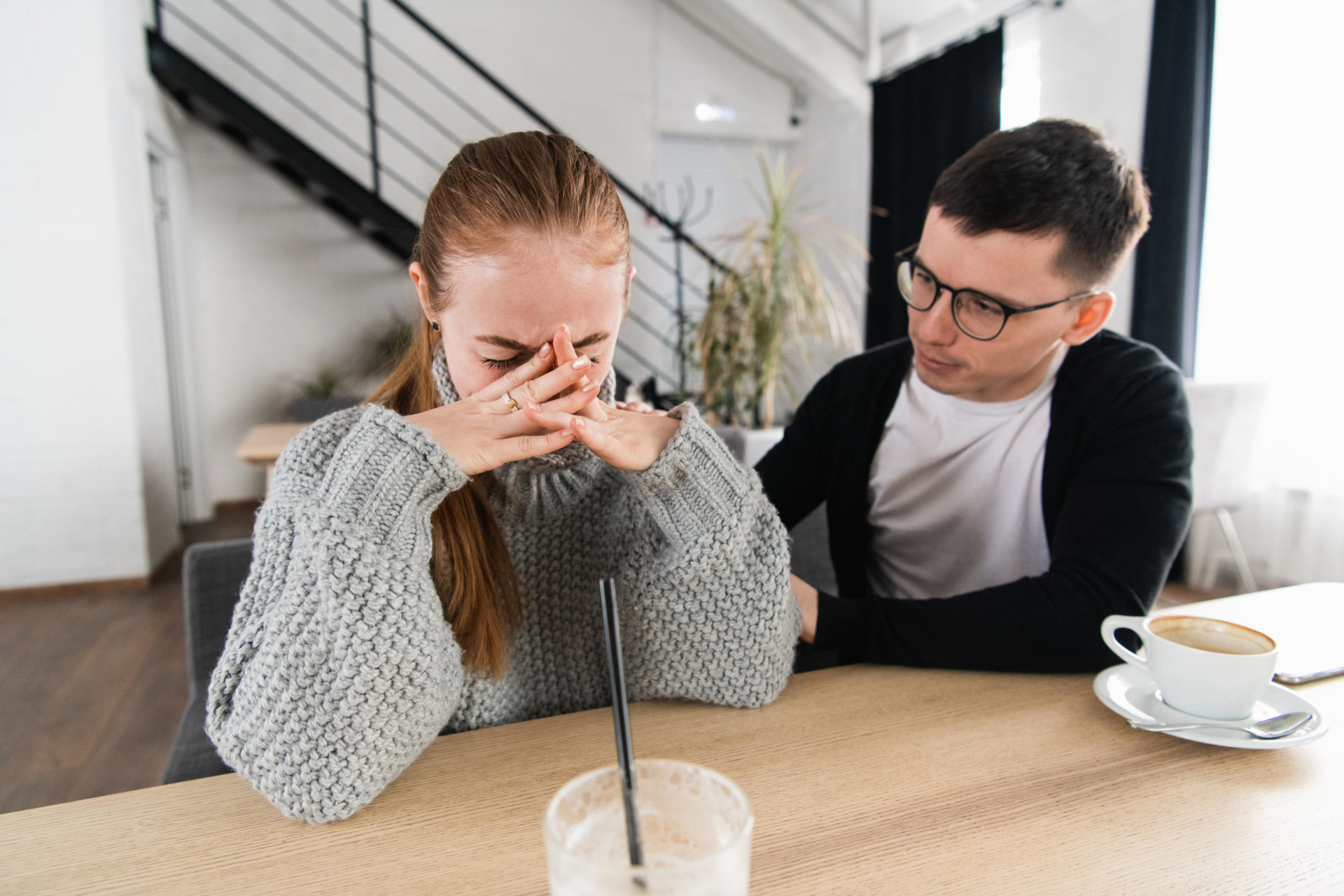 A man comforts a woman as she cries