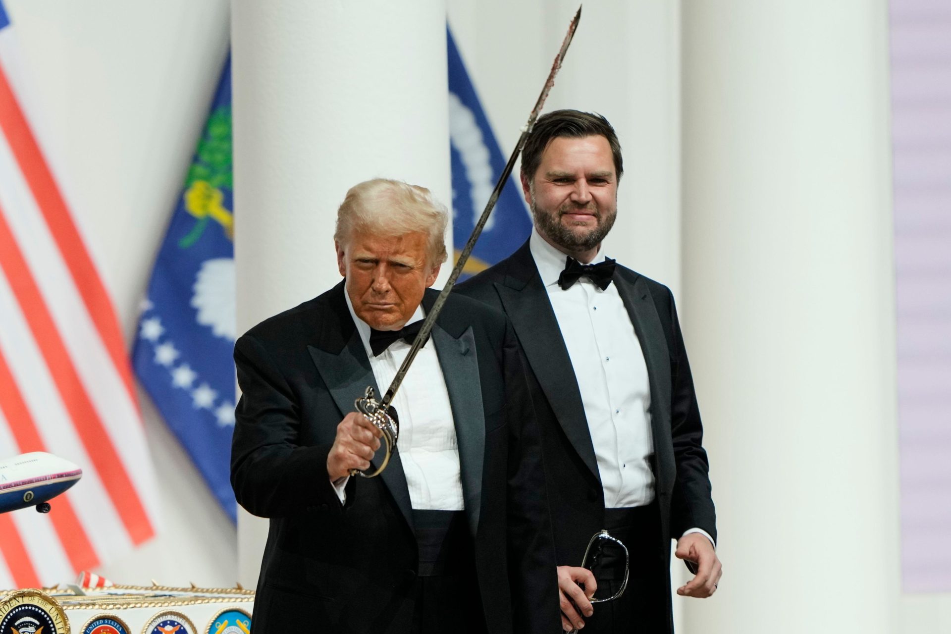 2S84MND President Donald Trump, left, holds a sabre after using it to cut a cake, as Vice President JD Vance looks on, at the Commander in Chief Ball, part of the 60th Presidential Inauguration, Monday, Jan. 20, 2025, in Washington. (AP Photo/Ben Curtis)