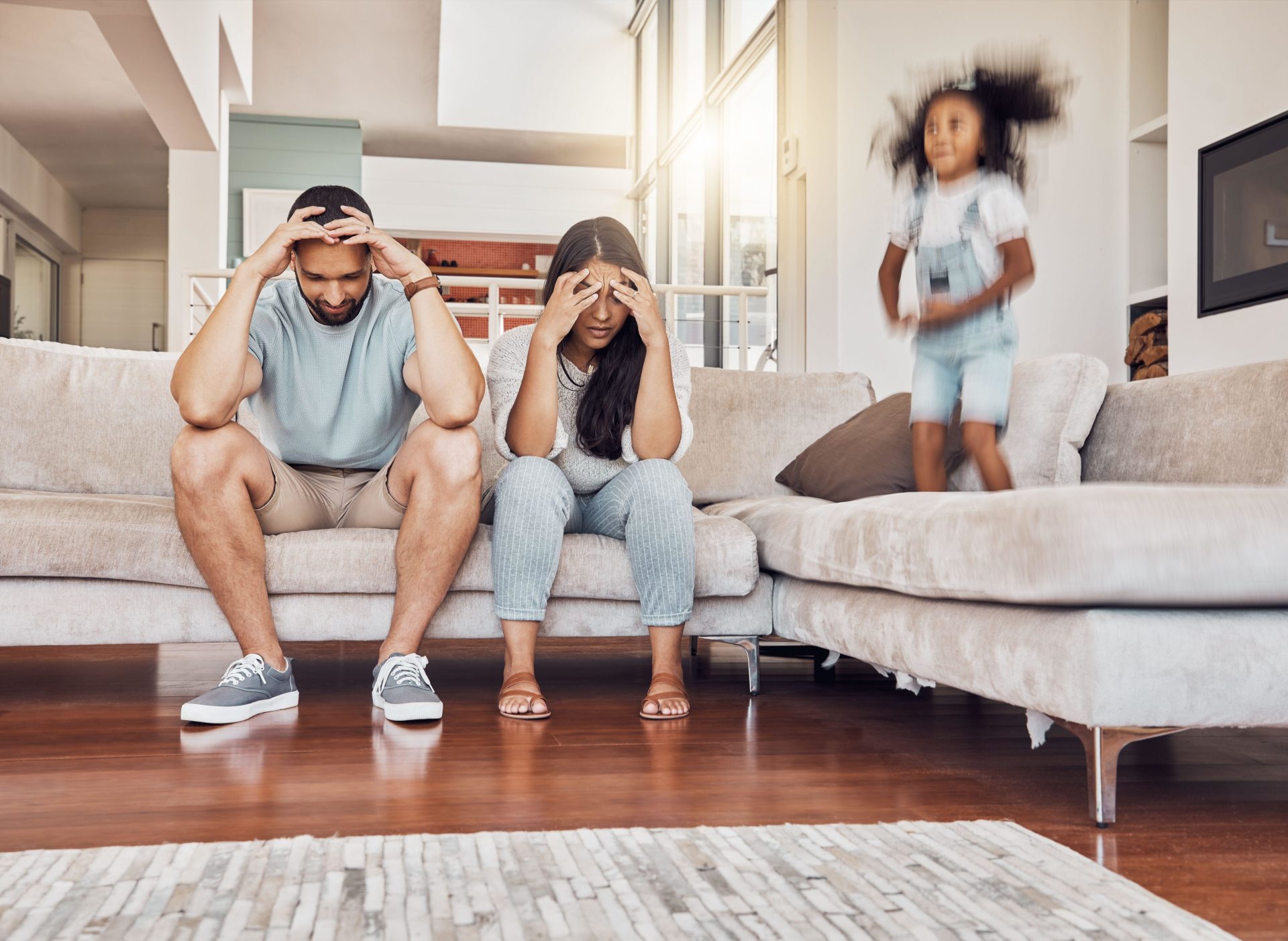 Tired parents, frustrated and active child being naughty and playful.