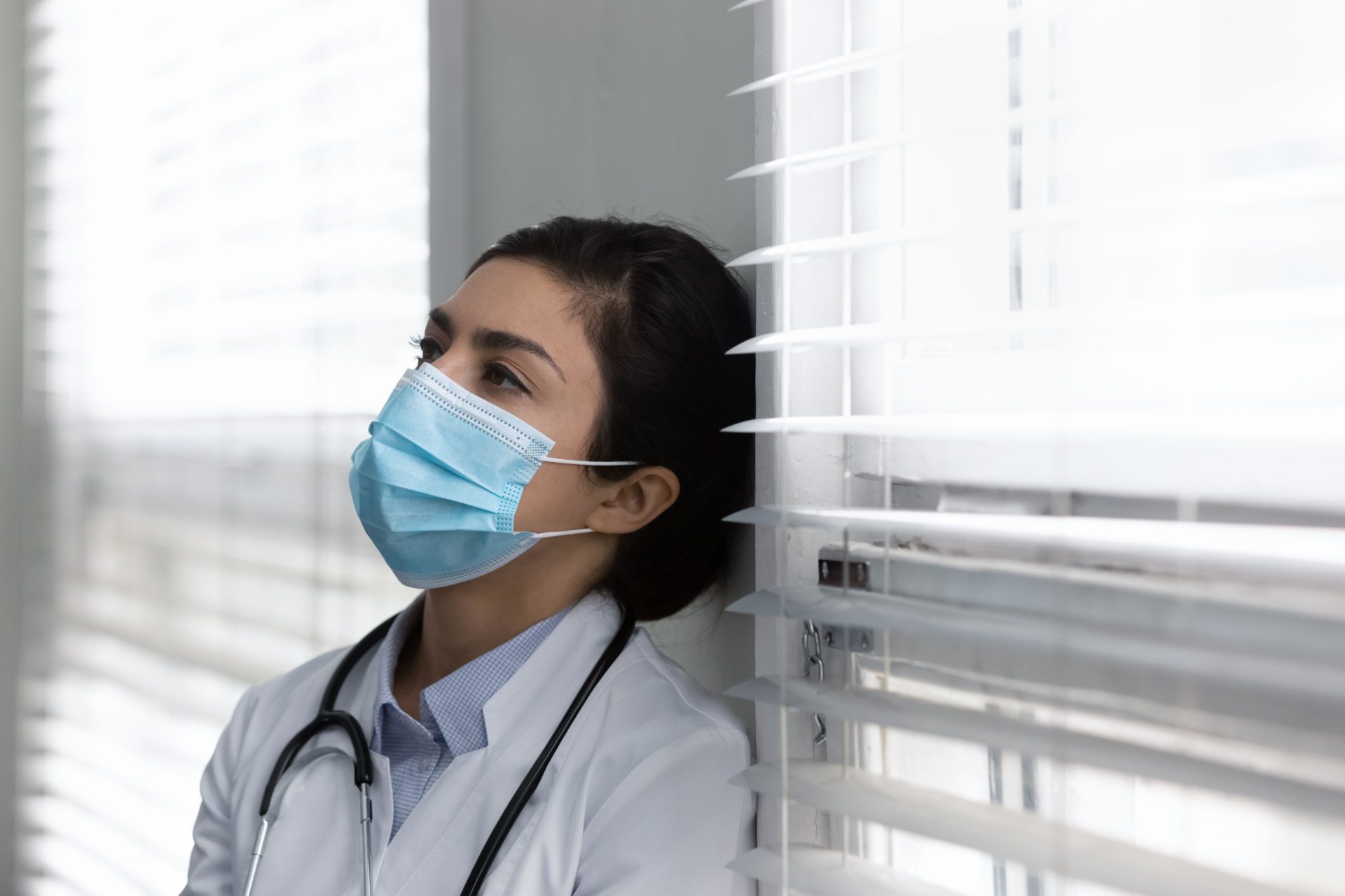 Unhappy doctor feeling exhausted in clinic.