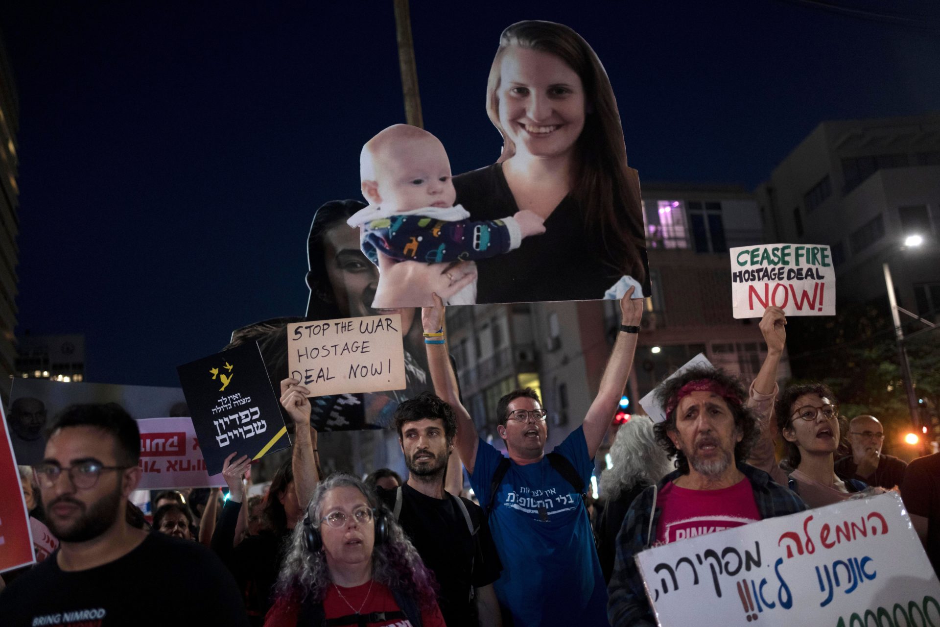 Families and their supporters carry large photos depicting women held hostage by Hamas. May 8, 2024. At centre is Shiri Bibas with her child, Kfir; at left is Noa Argamani.