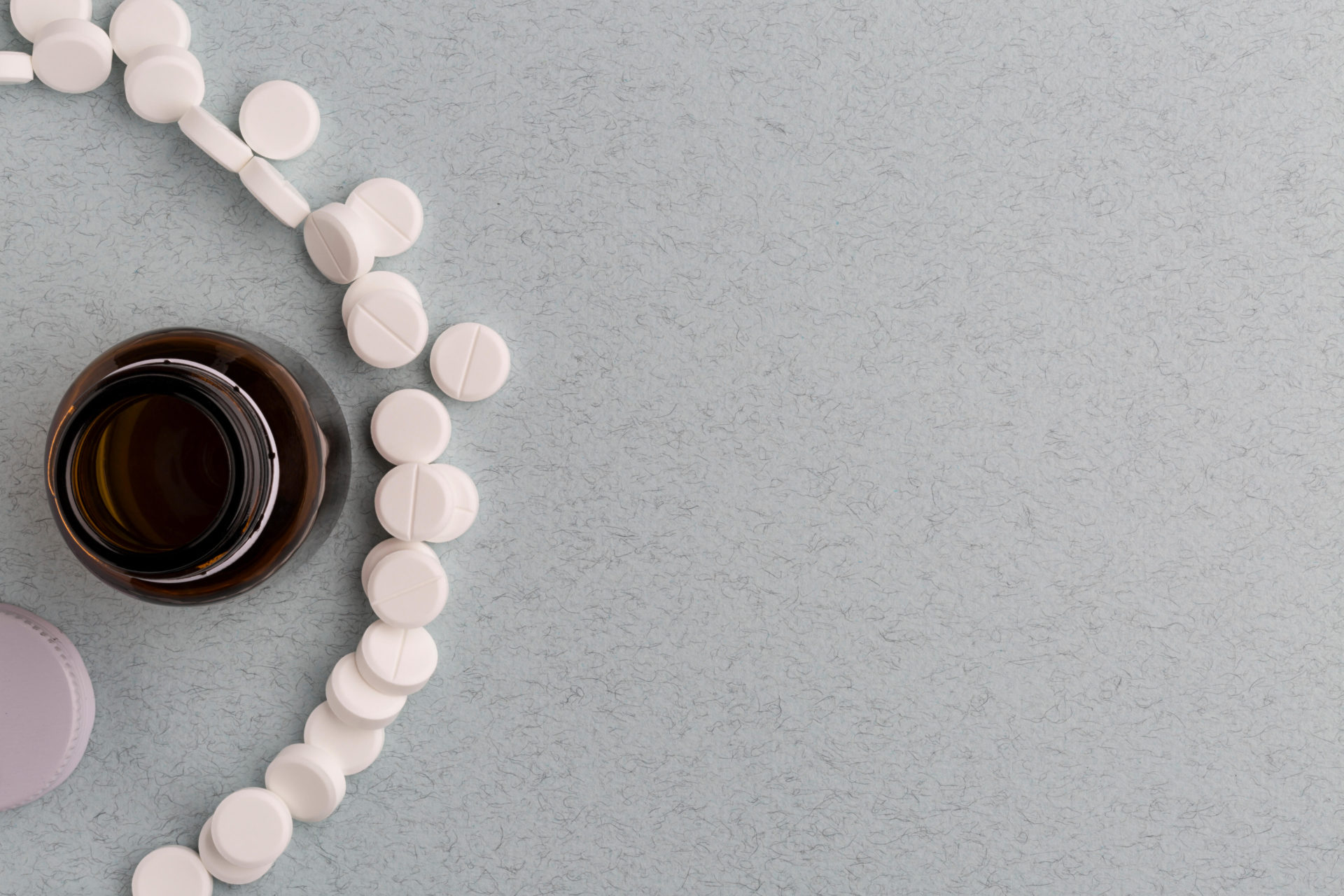 Brown glass pill bottle and white pills. Image: Alamy