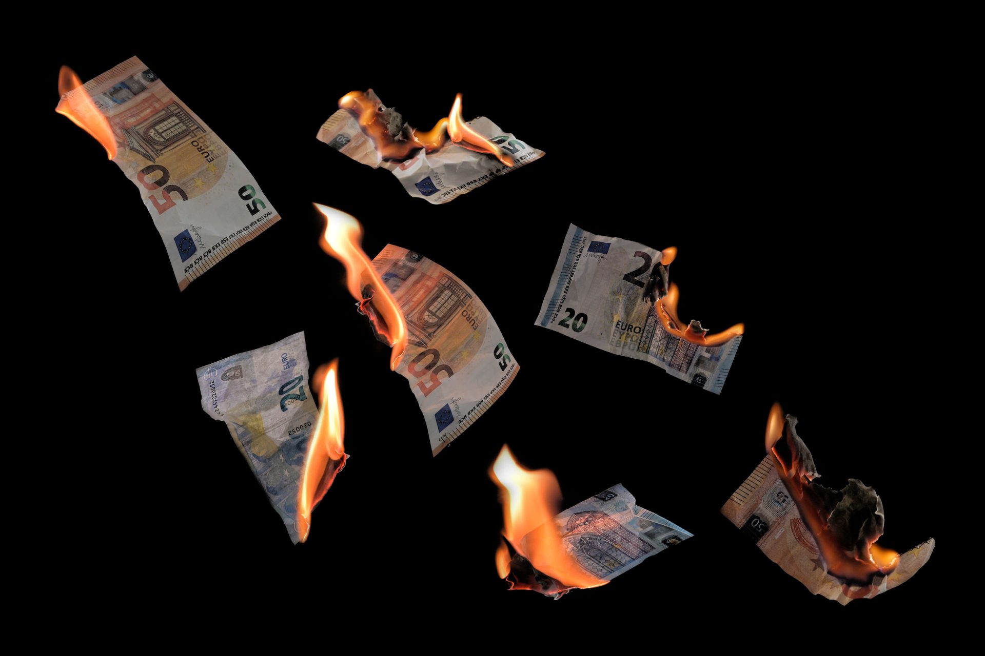 Burning money, twenty and fifty euro banknotes with flames flying.