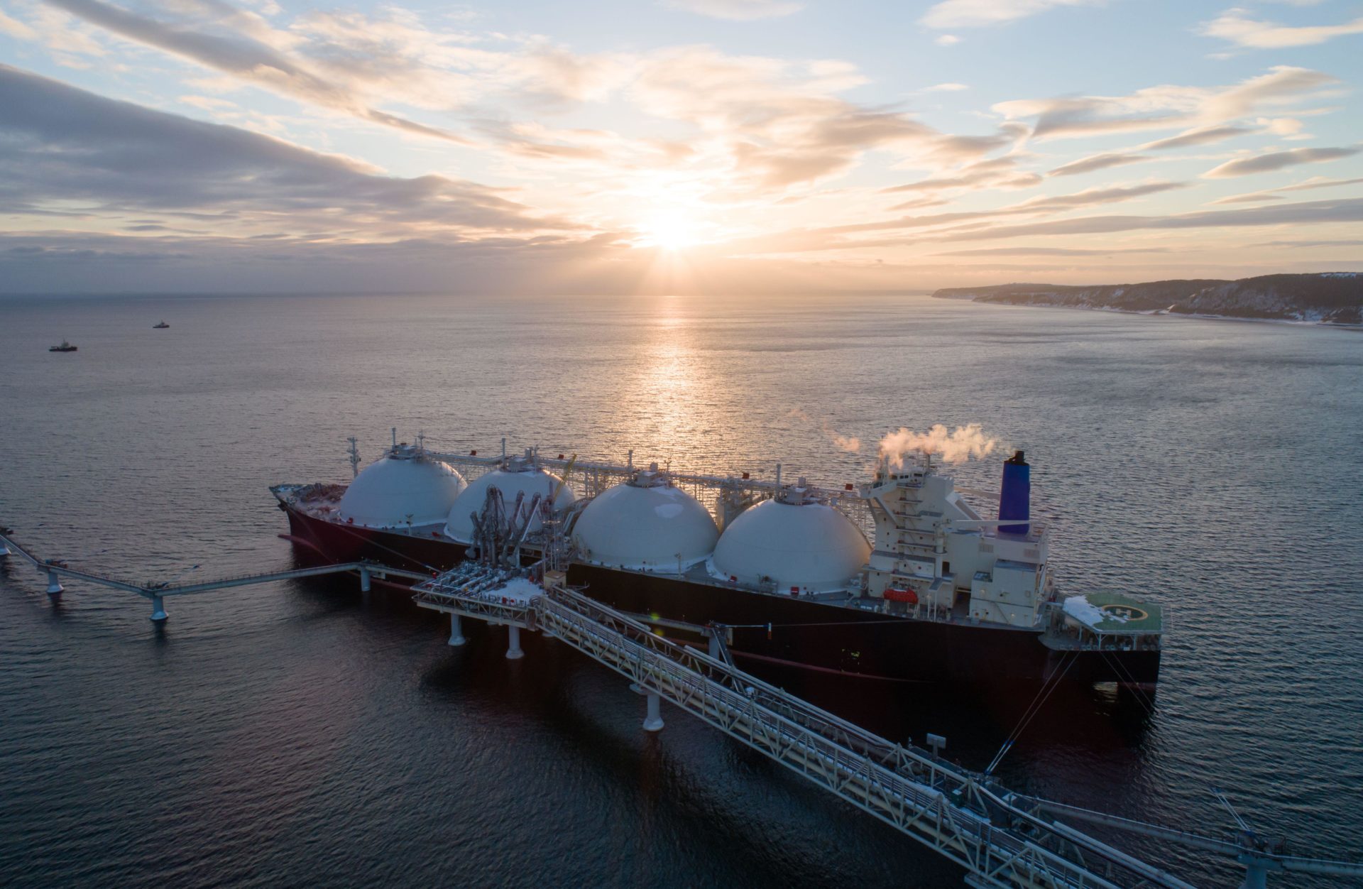 Aerial of Liquified Natural Gas LNG carrier moored to a small gas terminal. 