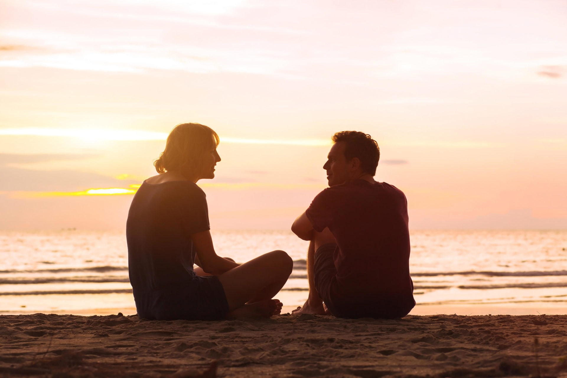 Man and woman on the beach at sunset. 