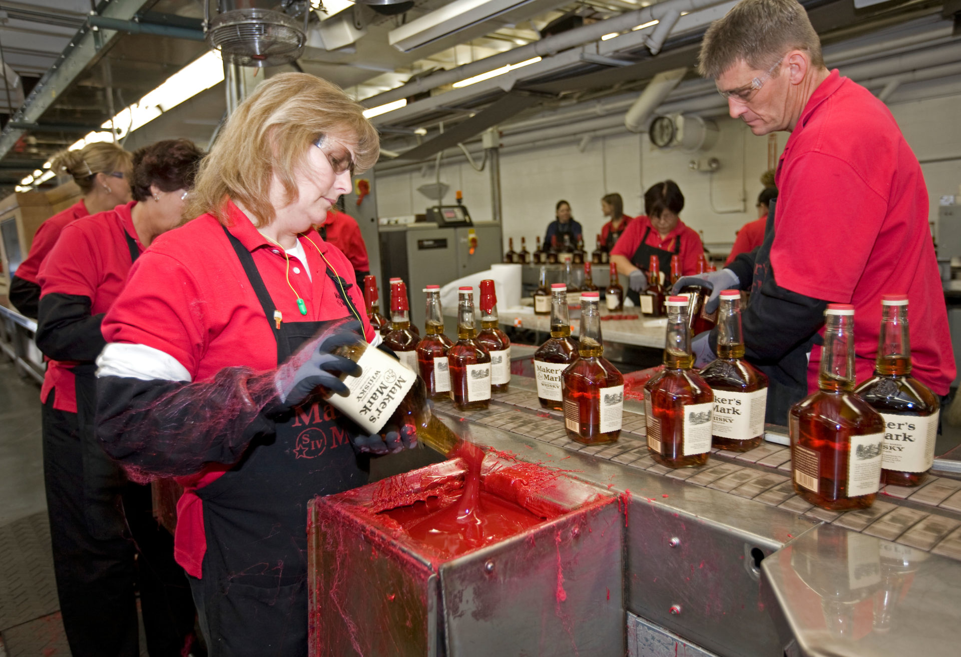 Workers sealing bourbon bottles at Maker's Mark Kentucky bourbon distillery, near Loretto, KY. Founded in 1953 by T.W. Samuels.