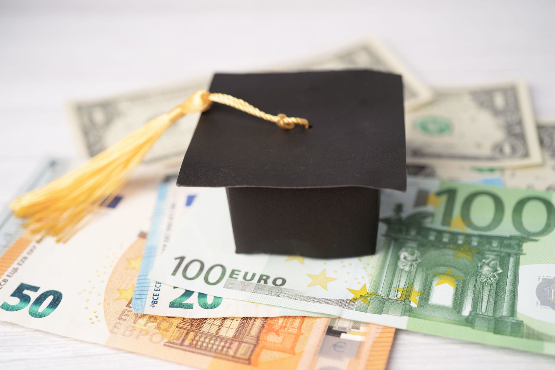 Graduation gap hat on Euro and US dollar banknotes money, Education study fee learning teach concept.