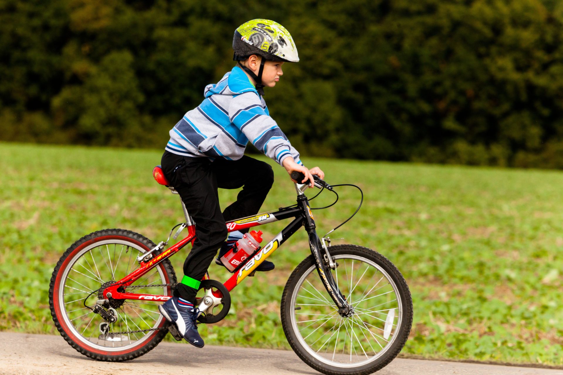 Child biker with helmet, boy ride bicycle. Alamy.com