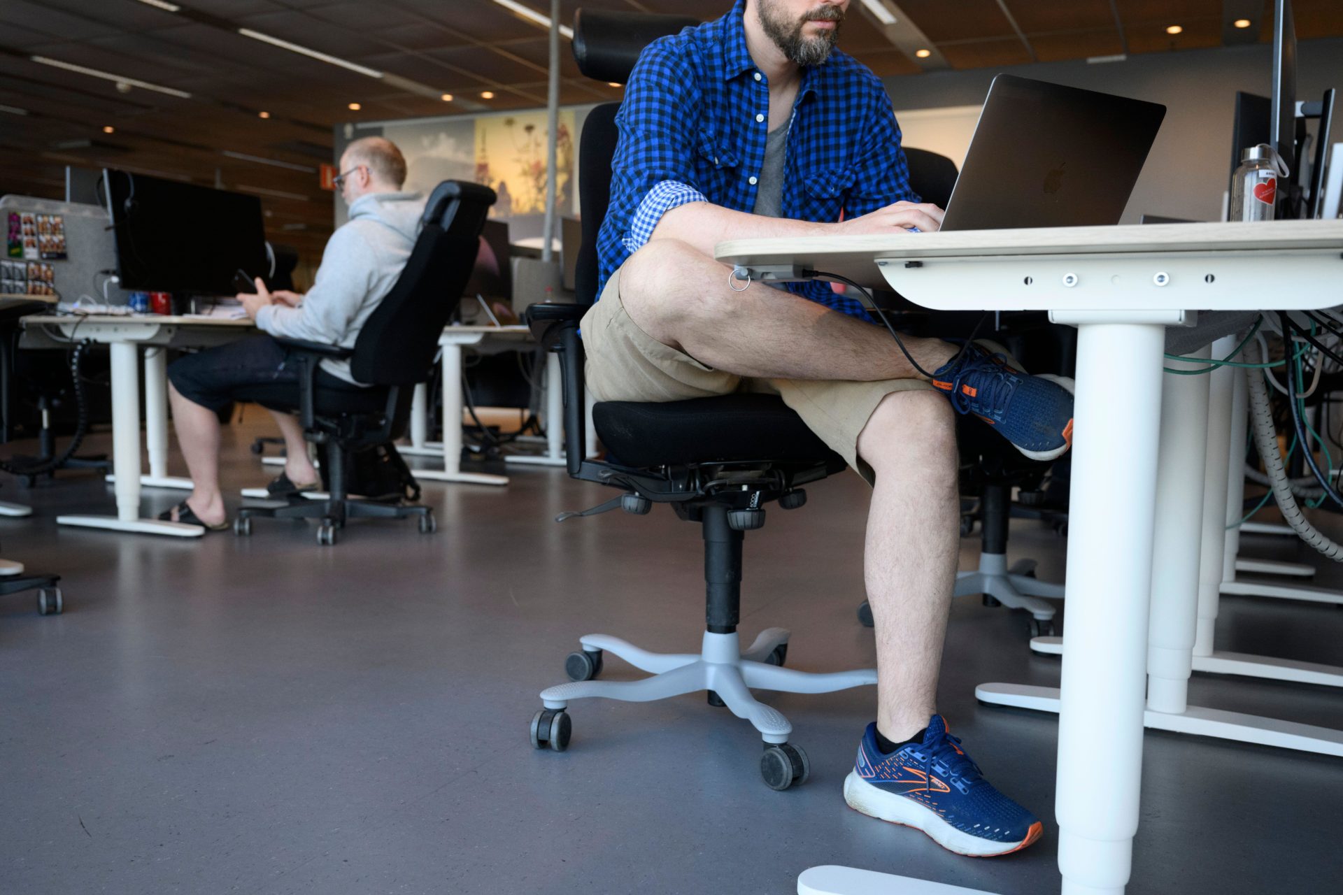 Two men wearing shorts at the the office in the work place.