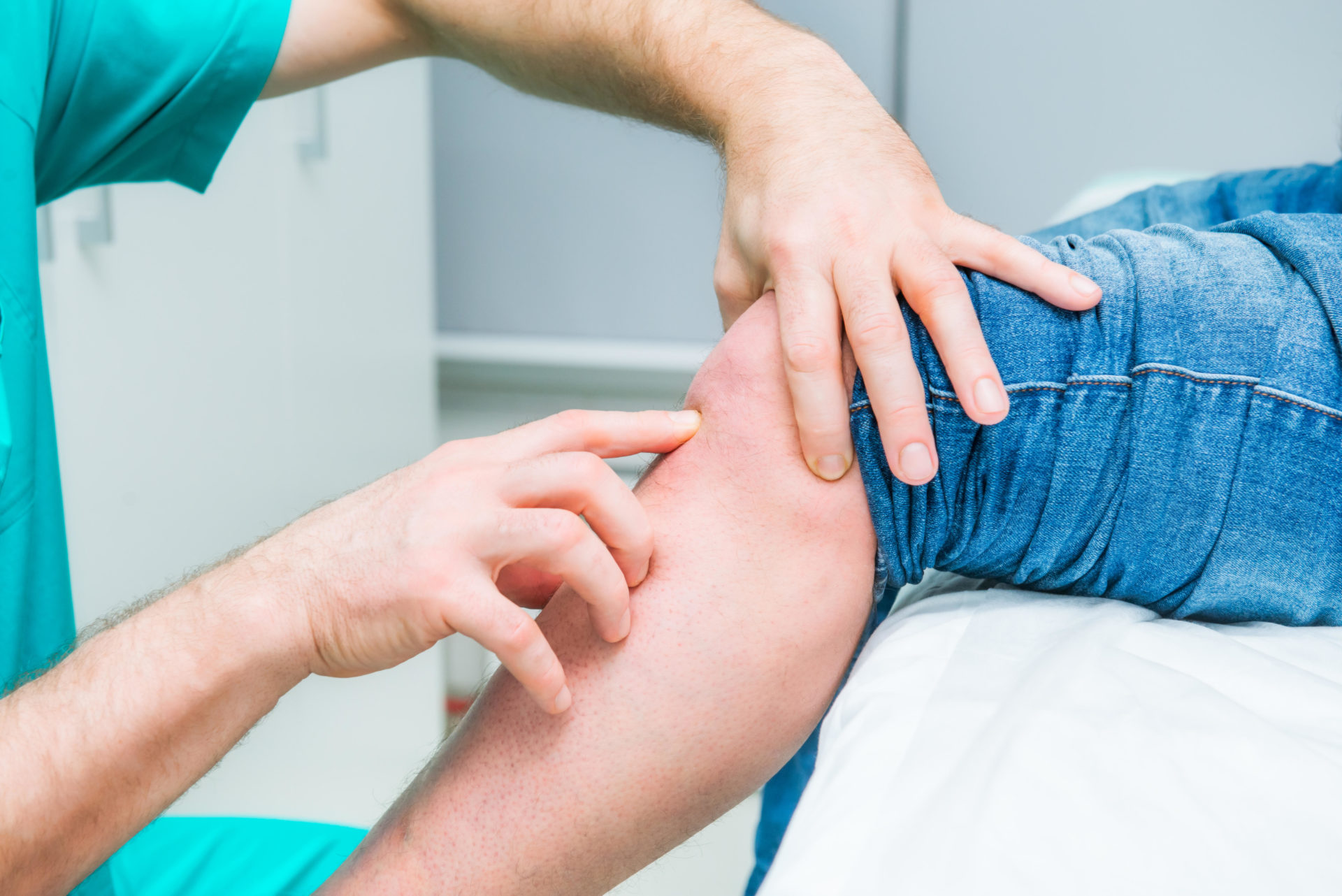 The neurologist doctor testing knee of male patient by finger pulpation
