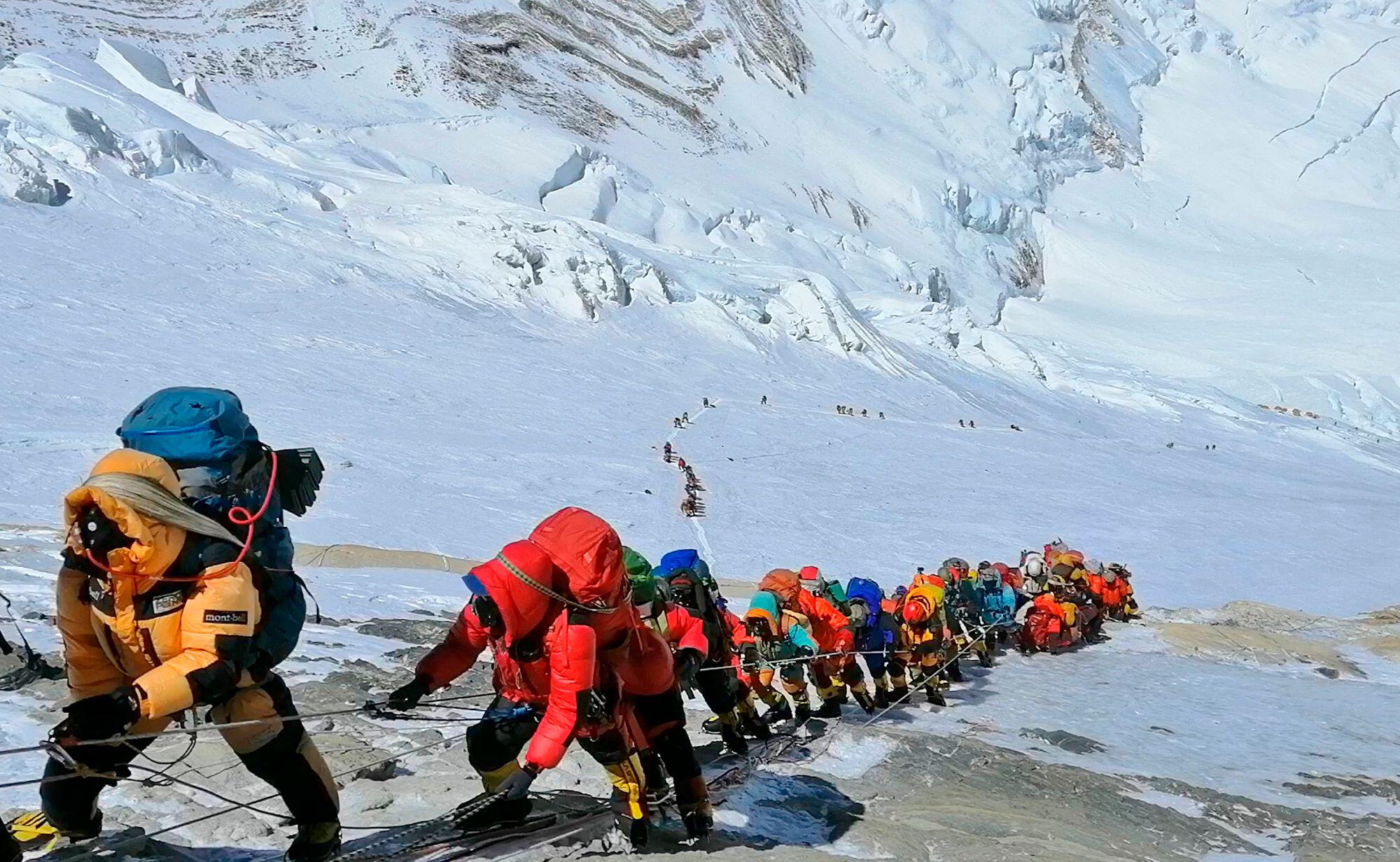 A long queue of mountain climbers line a path on Mount Everest.