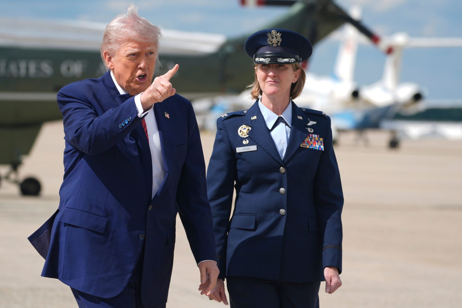 President Donald Trump walks from Marine One with Air Force Col. Angela Ochoa, Commander of the 89th Airlift Wing, to board Air Force One to depart Joint Base Andrews, Md.