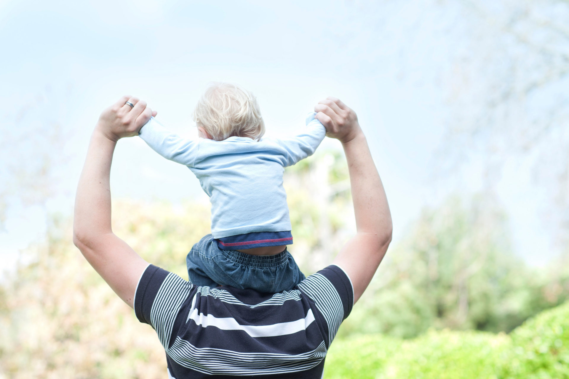 Father with baby son on shoulders.
