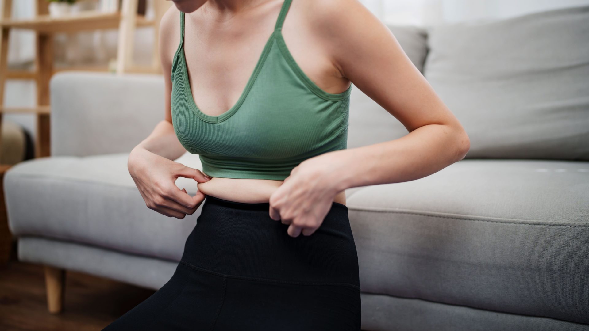 Woman holding belly fat, healthcare and wellness concept, diet and loss weight.