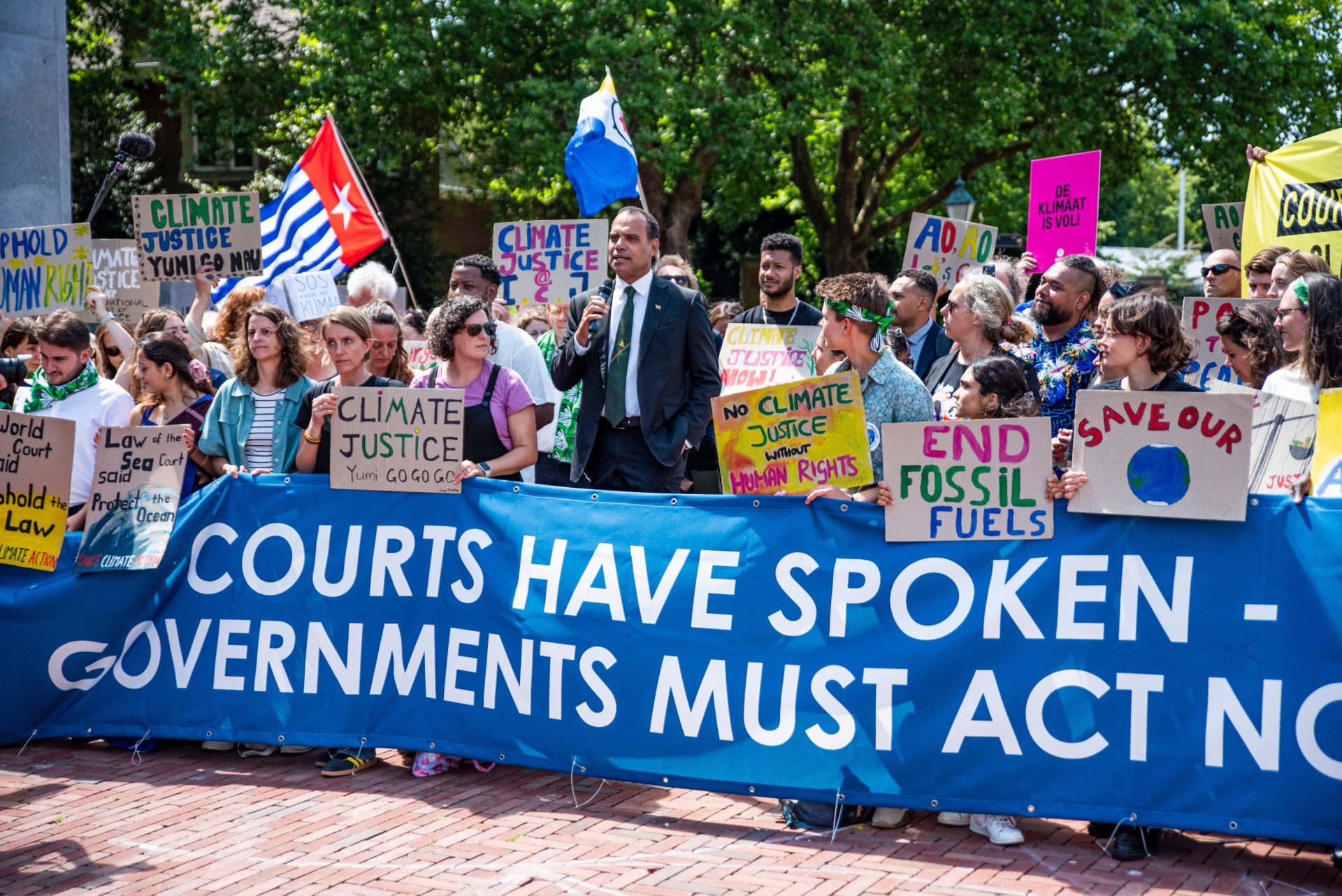 Climate and human rights activists demonstrate before the International Court of Justice.