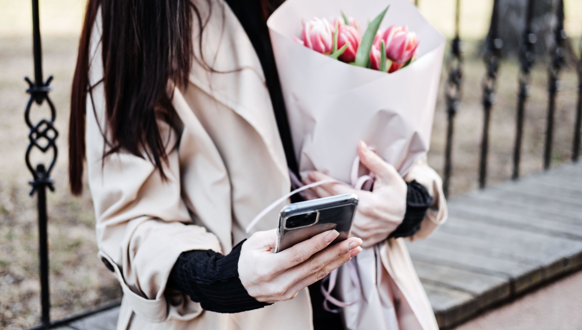 Happy smiling woman with flowers bouquet using social media.