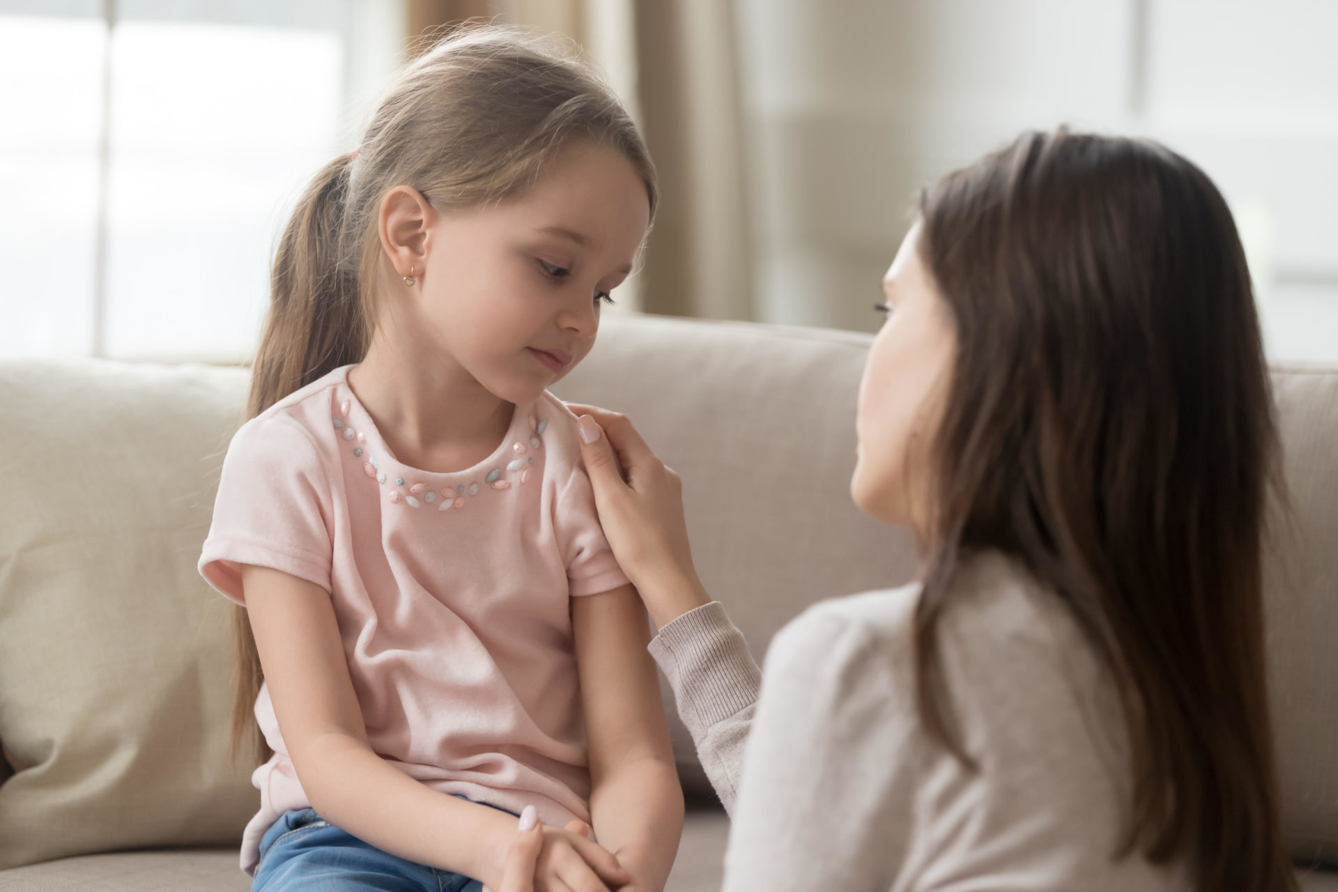 Loving mom talking to upset little child girl giving support.