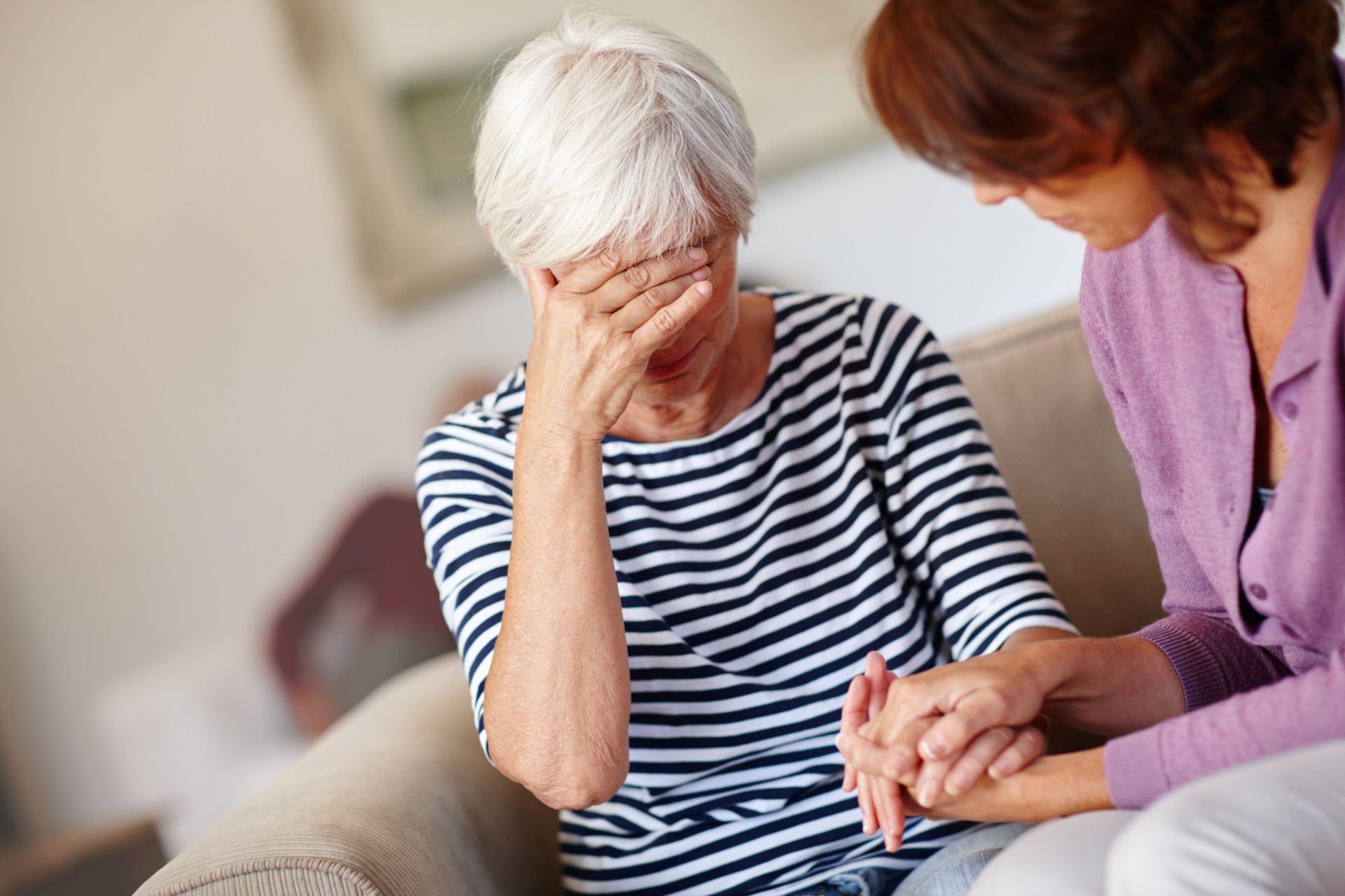 Woman comforting her elderly mother whos upset.