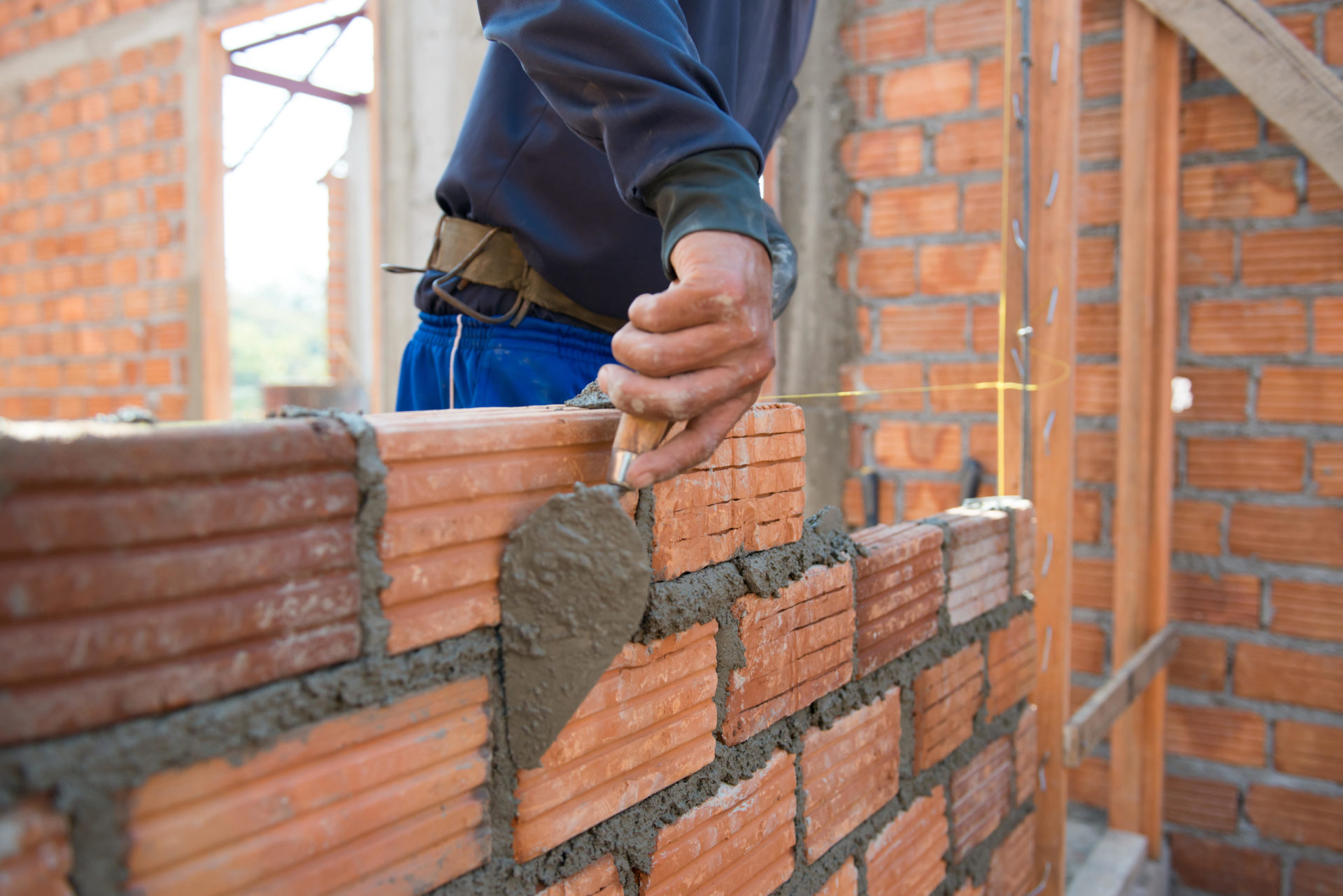 EXNNF9 Worker building masonry house wall with bricks
