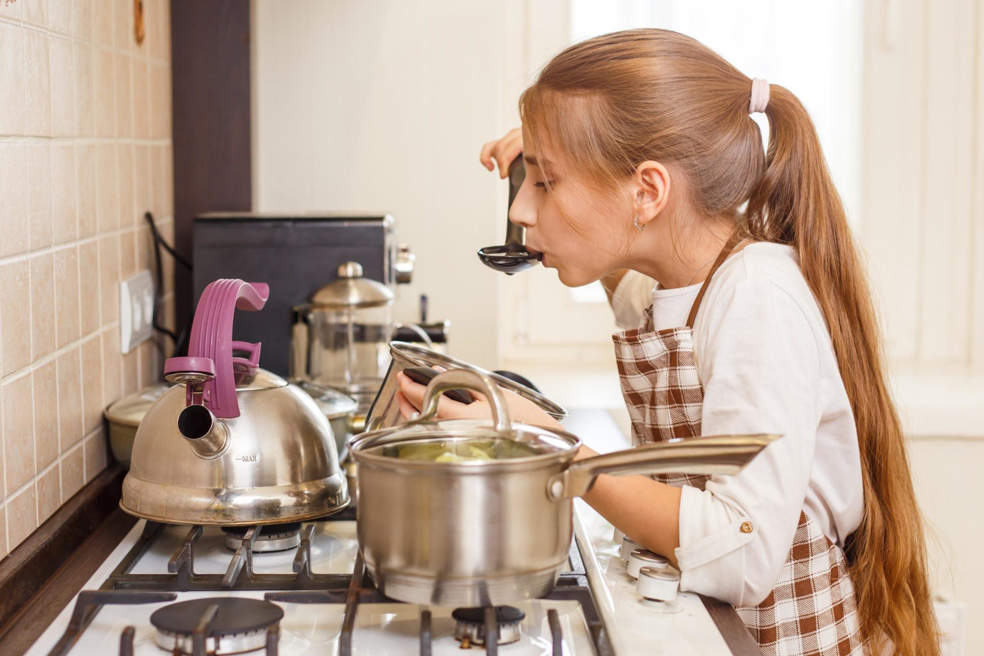 Teenage girl cooking in the home kitchen. 