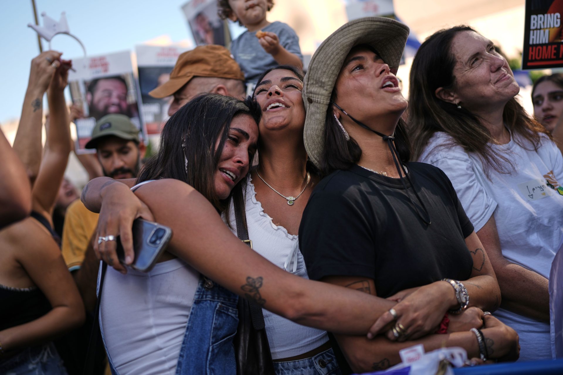 People react as they gather to watch a live broadcast of Israeli hostages released from Gaza at a plaza known as hostages square in Tel Aviv, Israel, Monday, Oct. 13, 2025. The release took place as part of a cease-fire agreement between Israel and Hamas. 