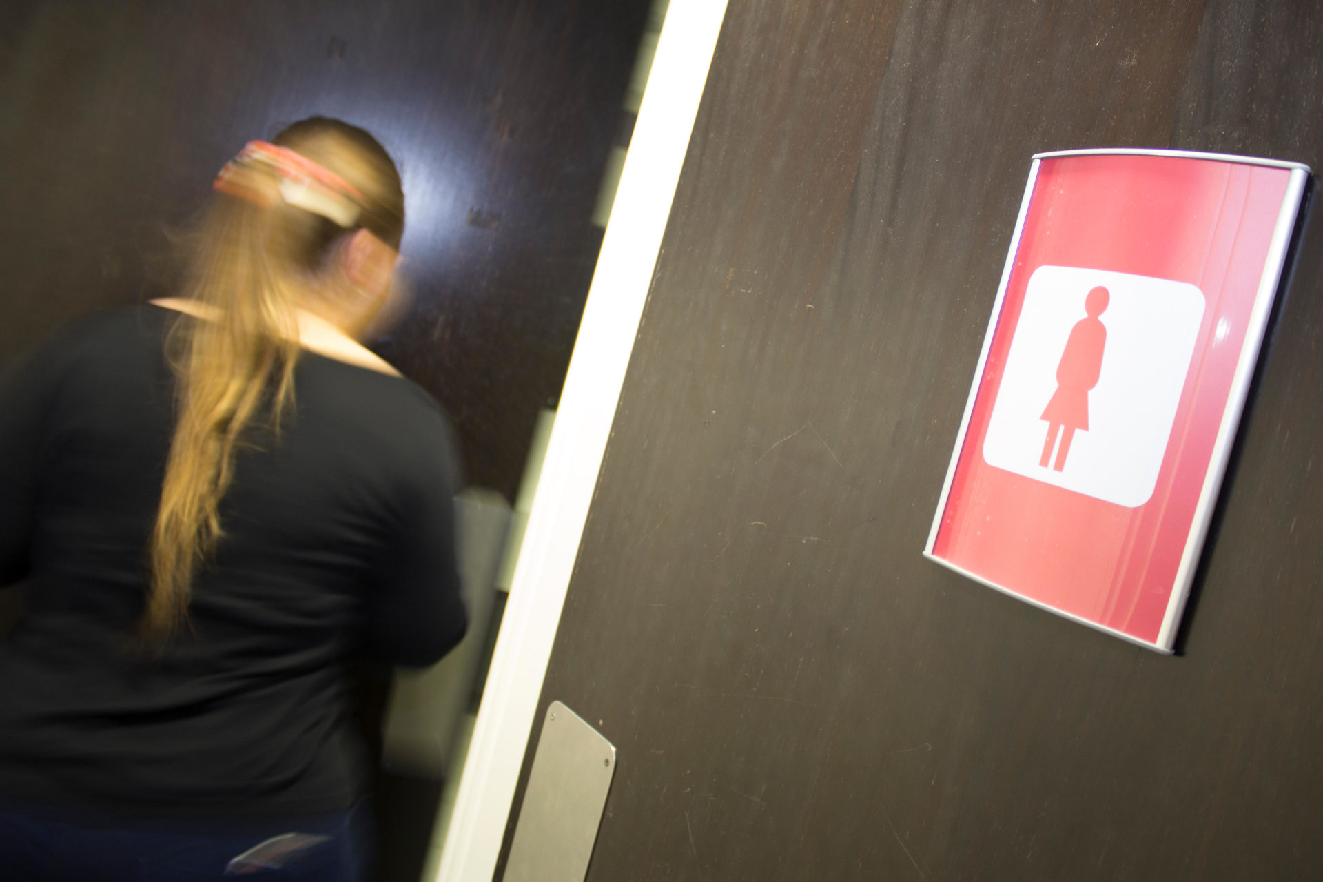 HPN4DH Someone with a ponytail walks into the women's toilets.