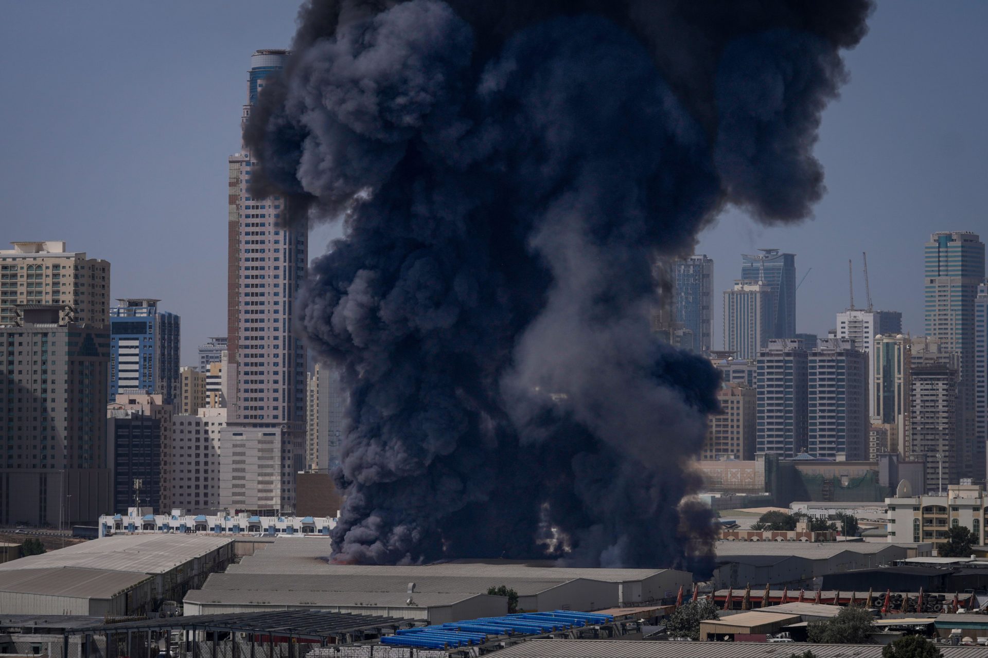 3DX4B5N A black plume of smoke rises from a warehouse at the industrial area of Sharjah City in the United Arab Emirates following reports of Iranian strikes in Dubai, United Arab Emirates, Sunday, March 1, 2026. (AP Photo/Altaf Qadri)